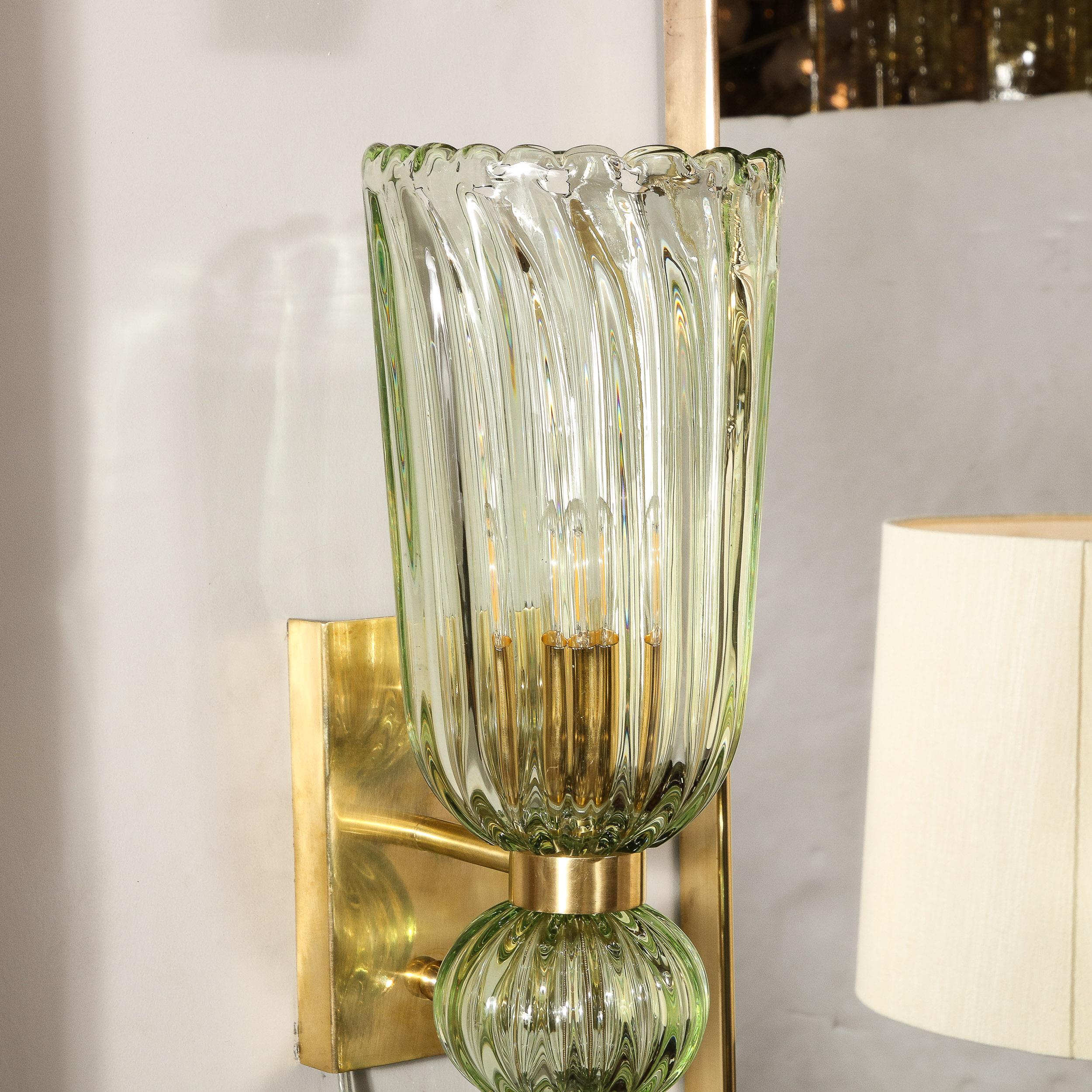 This elegantly reserved pair of sconces originates from Italy during the 21st century. Composed in a stunning celadon hue of semi-translucent handblown Murano glass, diffusing light and adding brilliant complexity of value across the vertically