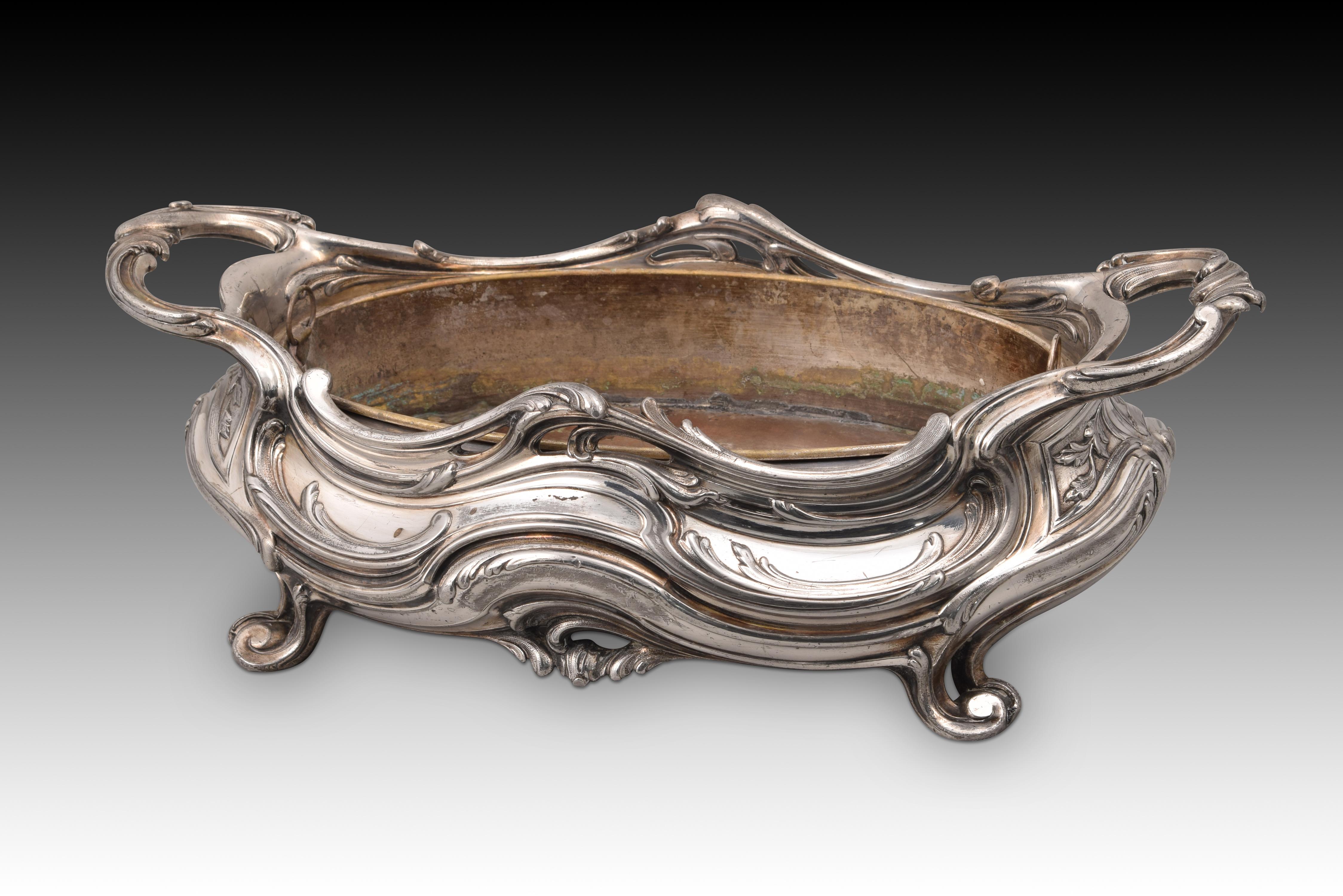 Modernist centerpiece. Tin, metal. Victor Saglier, late 19th century. 
With marks. Flowers not included.
Centerpiece with an oval-shaped interior metal tray, with legs finished in volutes and an exterior decoration based on plant elements drawing