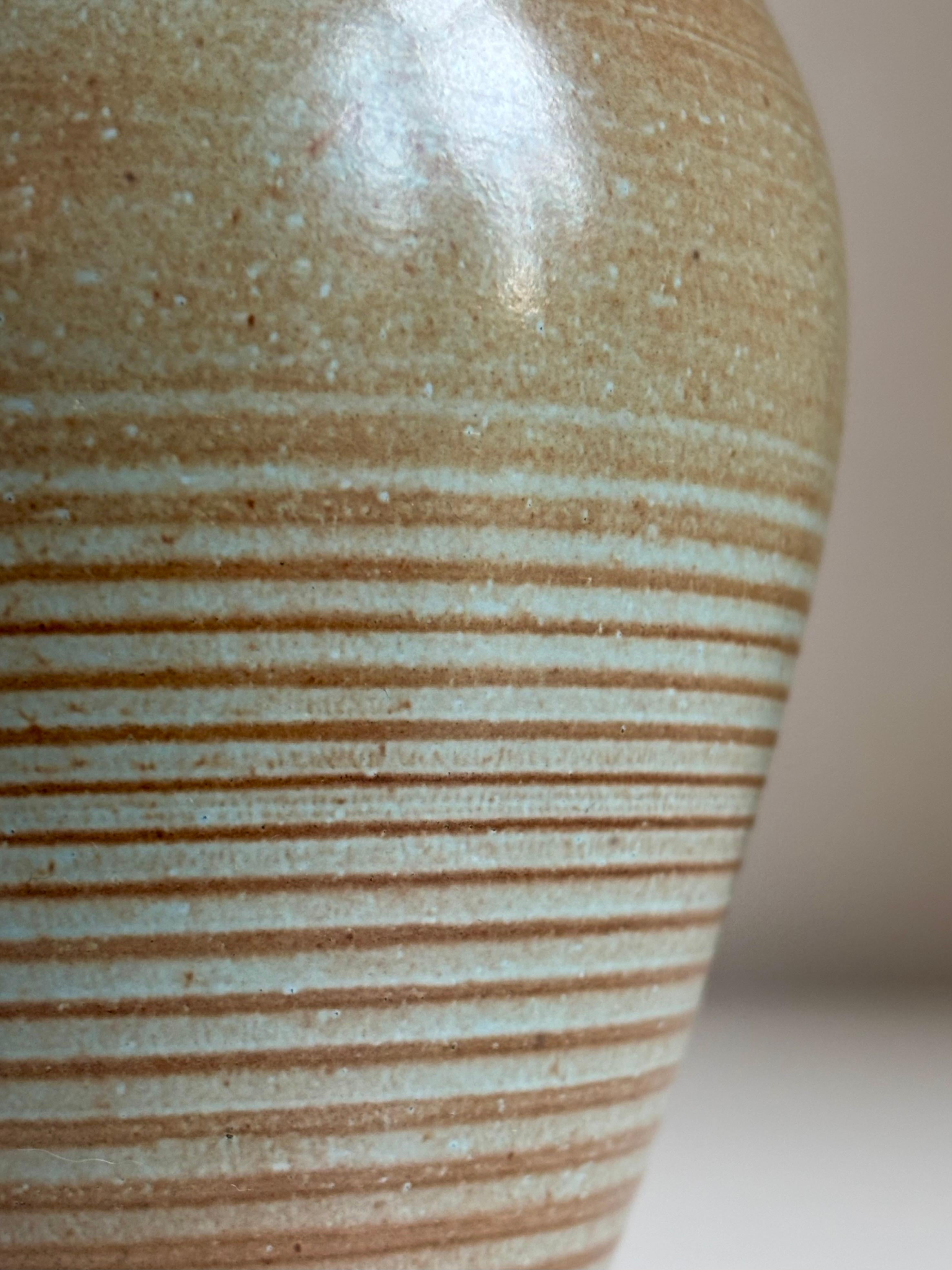 Vaso in ceramica della metà del secolo scorso tornito a mano con linee orrizontali. Smalto grigiastro con una sfumatura di menta sull'argilla color terracotta. Artista sconosciuto. 
Ottime condizioni vintage, coerenti con l'età e l'usura. Piccola