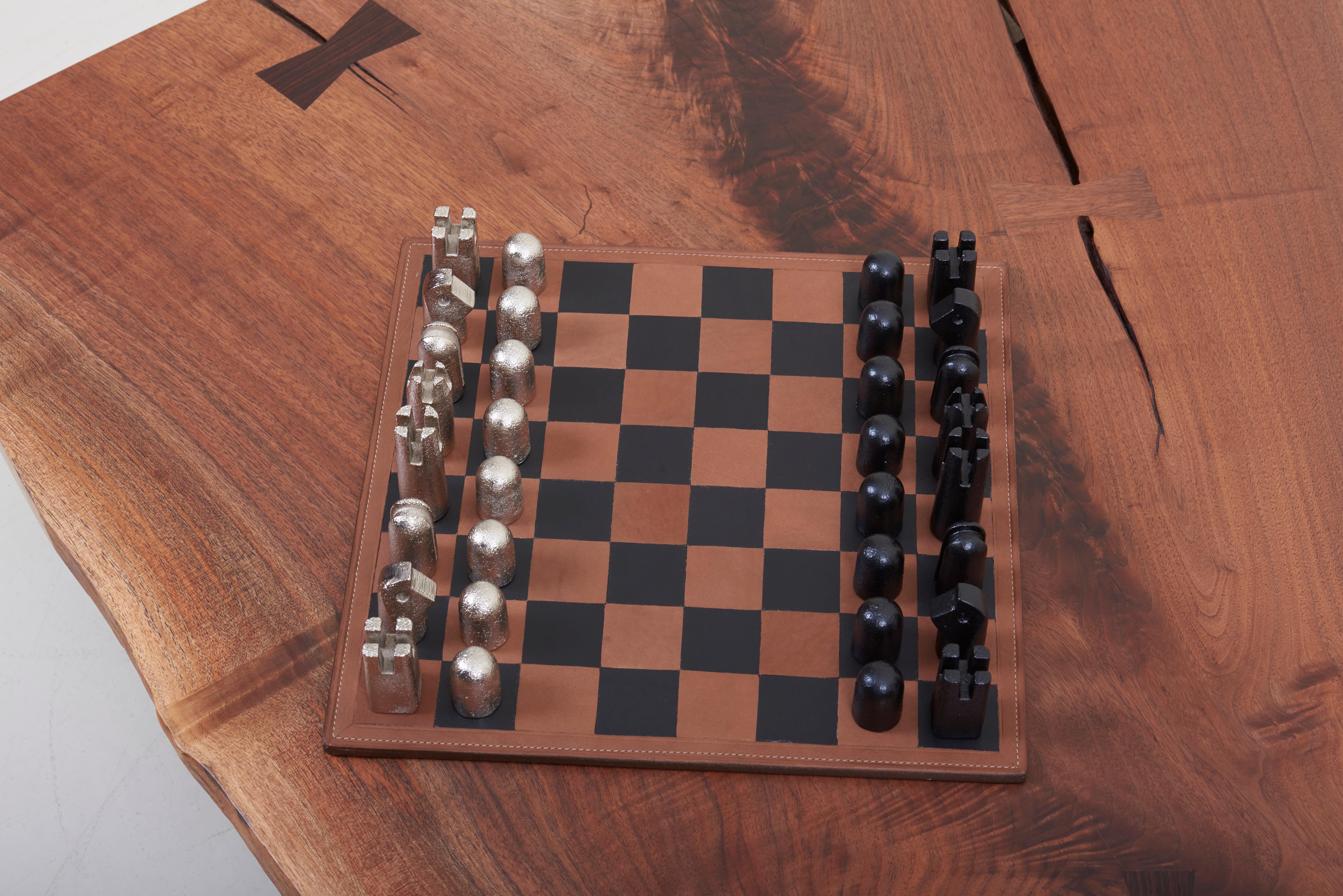 A chessboard made from black and natural leather with 32 nickel pieces.
Designed in the 1950s by Carl Auböck. Made in Vienna.