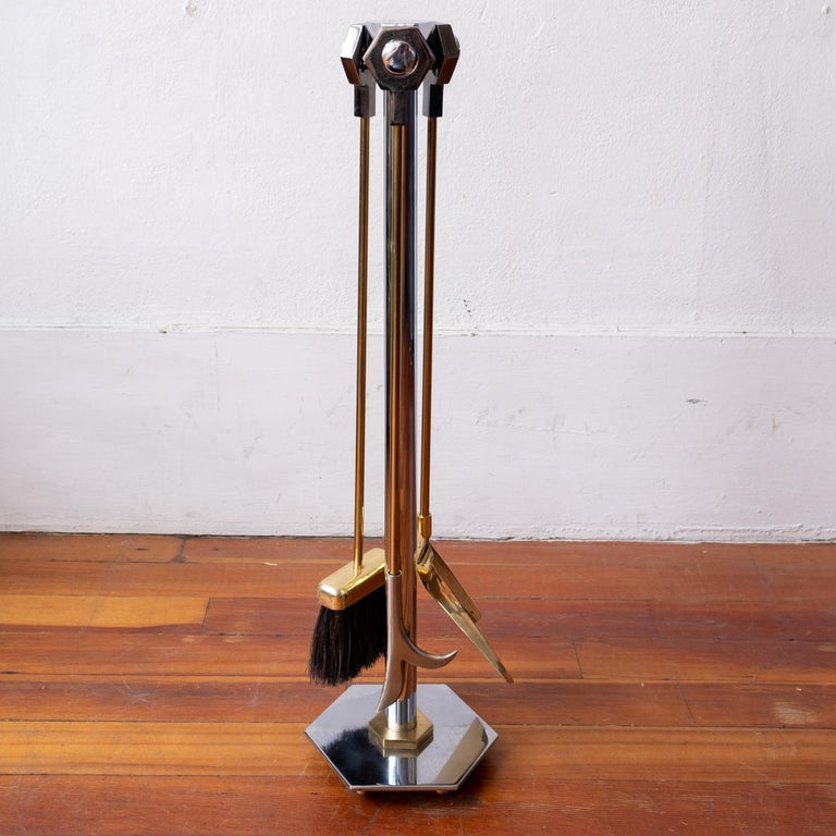 Modernist chrome and brass fire tools. The set includes a brush, poker and shovel with hexagonal handles. The solid metal stand has a hexagonal base.