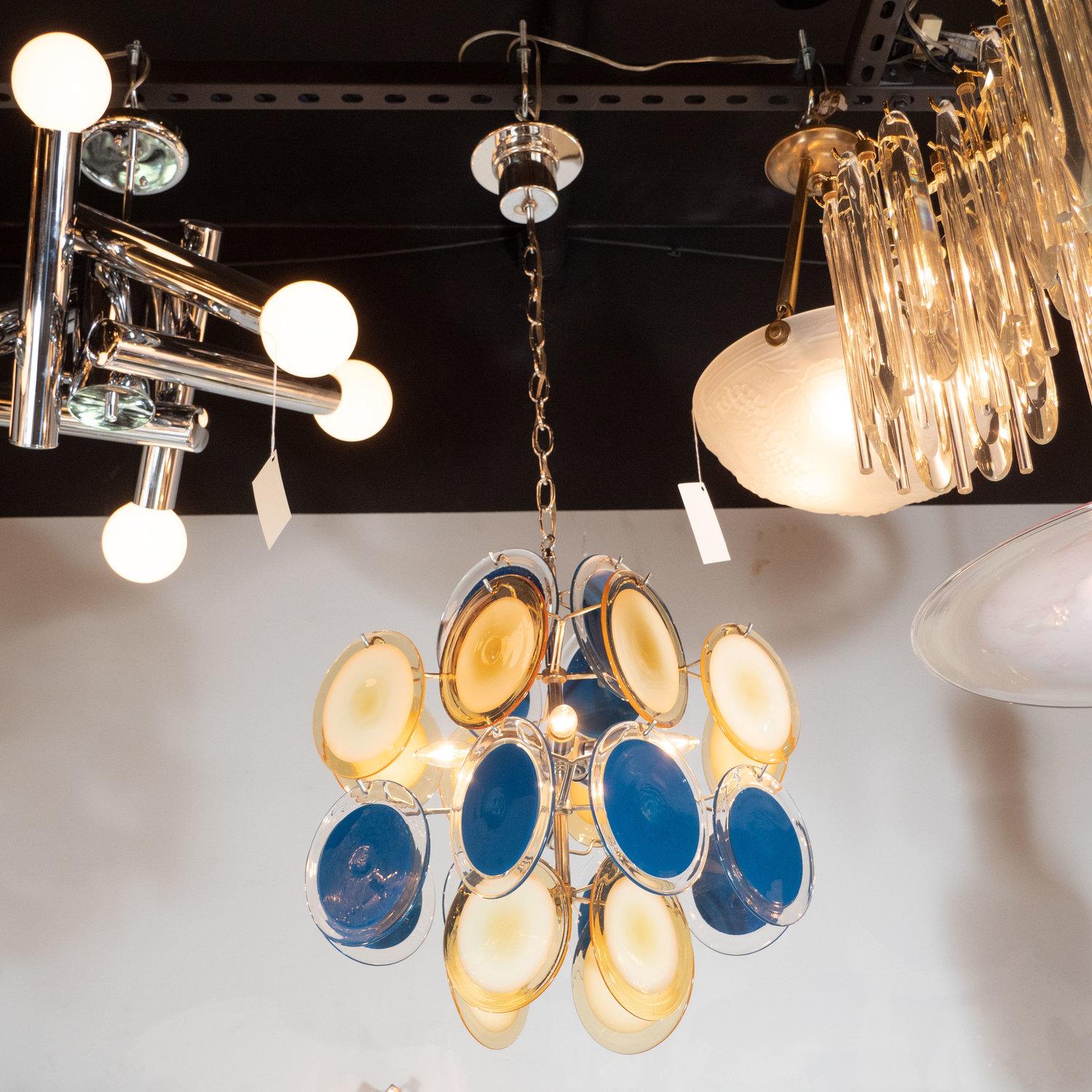 This sophisticated and vibrant chandelier was realized in Murano, Italy- the islands off the coast of Venice renowned for centuries for their superlative glass production. It features an abundance of handblown cerulean and straw yellow hued discs