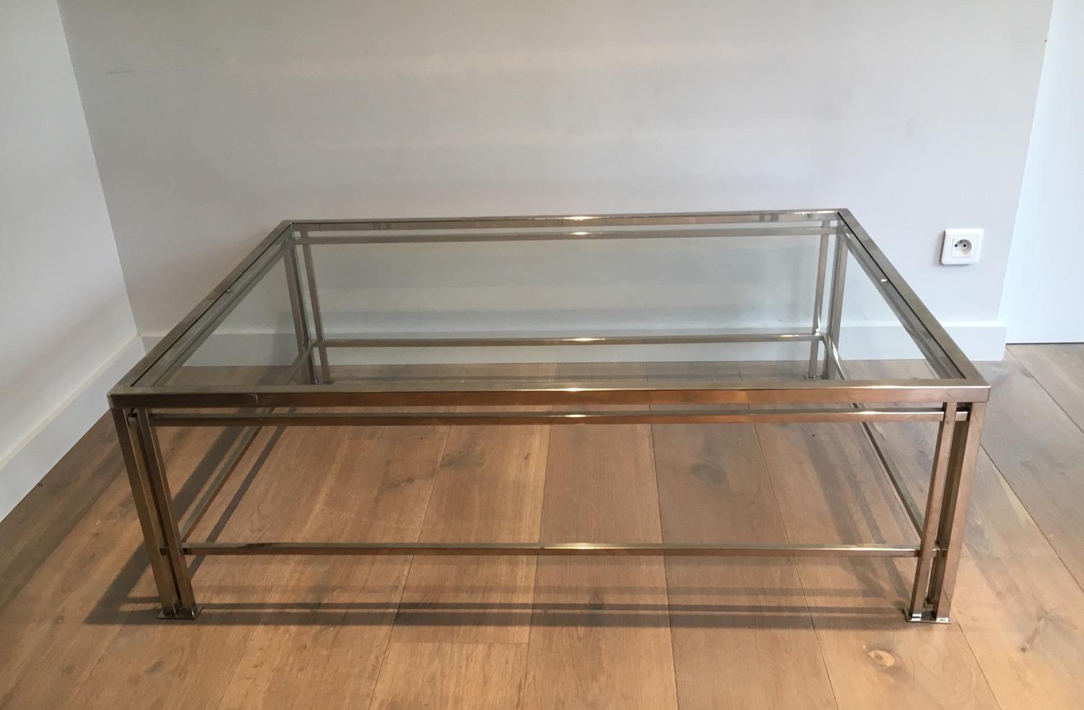 This modernist chrome coffee table with triple feet is made of chrome with 2 glass shelves. This is a French work. Circa 1970