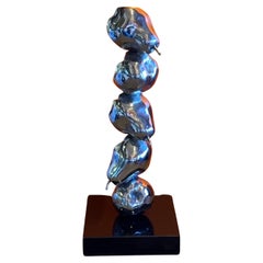 Escultura modernista de peras apiladas de cromo sobre mármol negro
