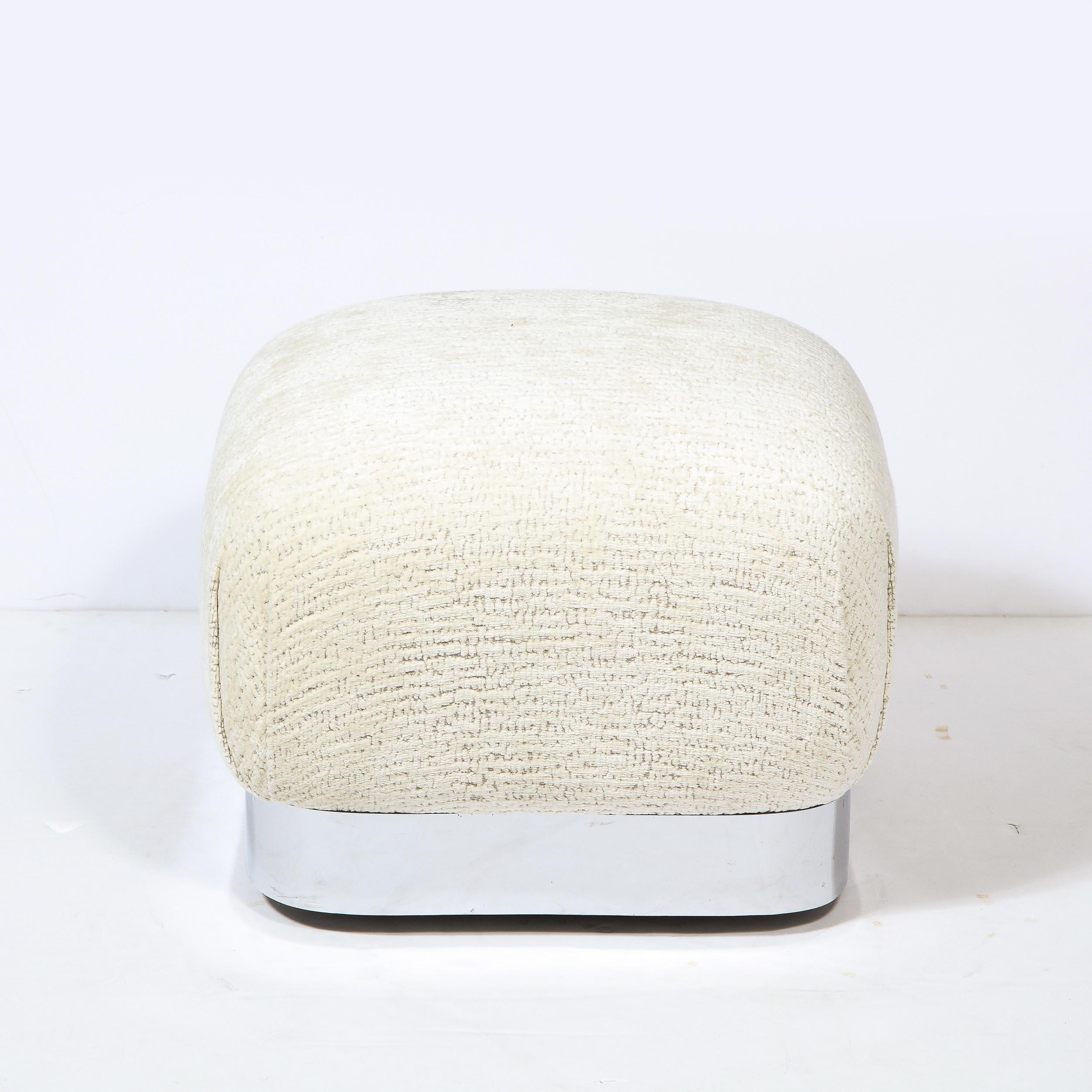 This stunning modernist ottoman was realized in the United States circa 1970. Executed in the manner of Karl Springer, it features a subtly domed concave body newly reupholstered in a luxurious cream gauffraged velvet. The base is wrapped wrapped in