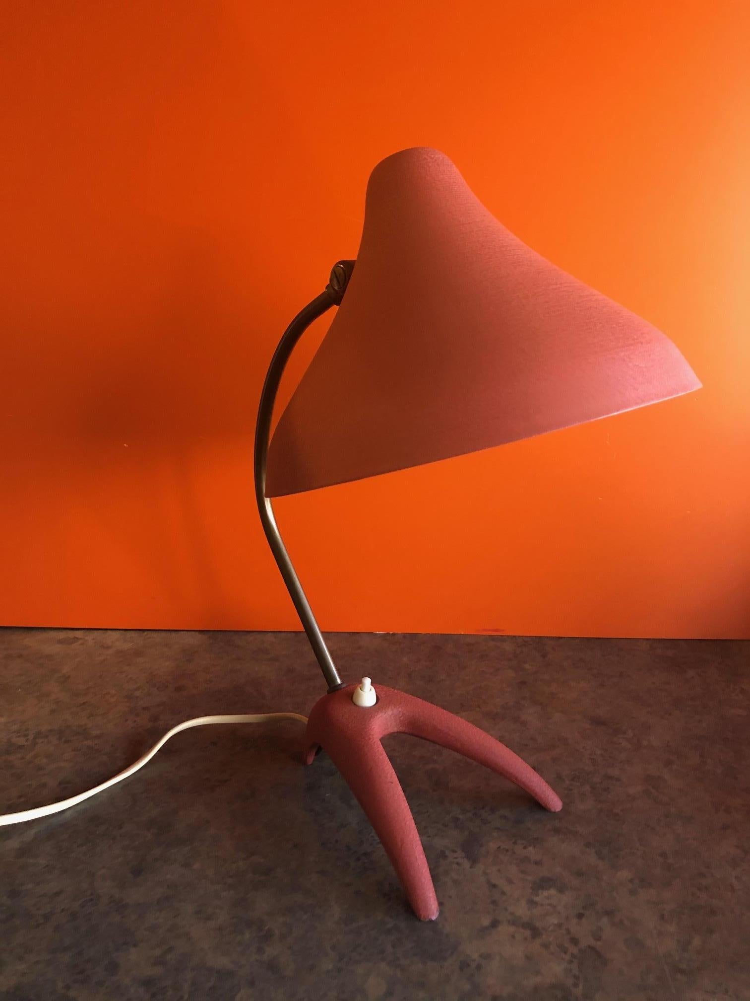 Modernist claw foot desk lamp by Louis Kalff for Phillips, circa 1950s. The lamp is in very nice original condition with original cord and red / orange paint. The conical shade is made of aluminum and is held by a curved brass stem (great patina) on