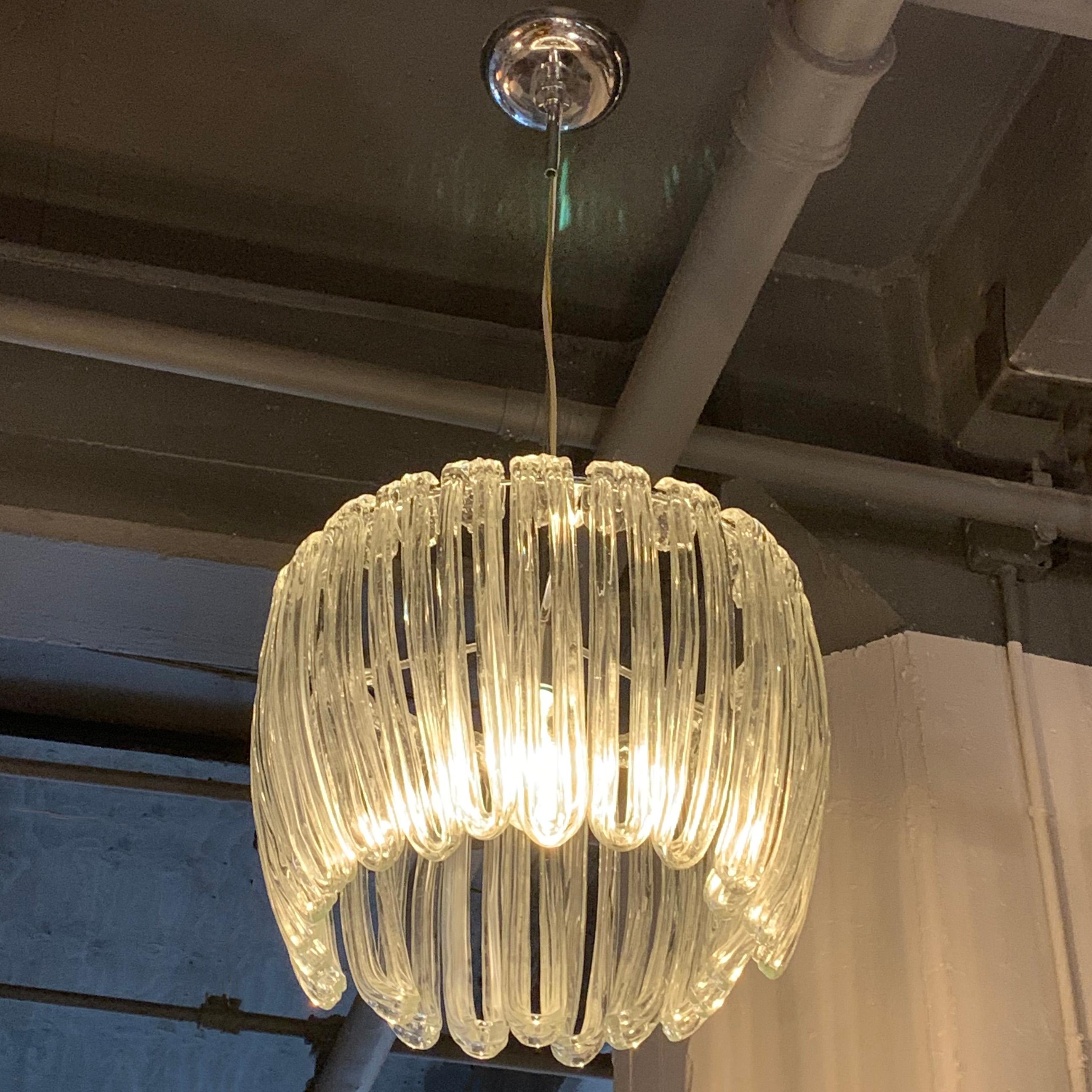 Modernist chandelier features multiple, organically shaped, clear blown glass tentacles that rest on a chrome frame resembling a jellyfish. The shade measures 17 inches diameter x 16 inches height. The pendant accepts one medium socket bulb up to