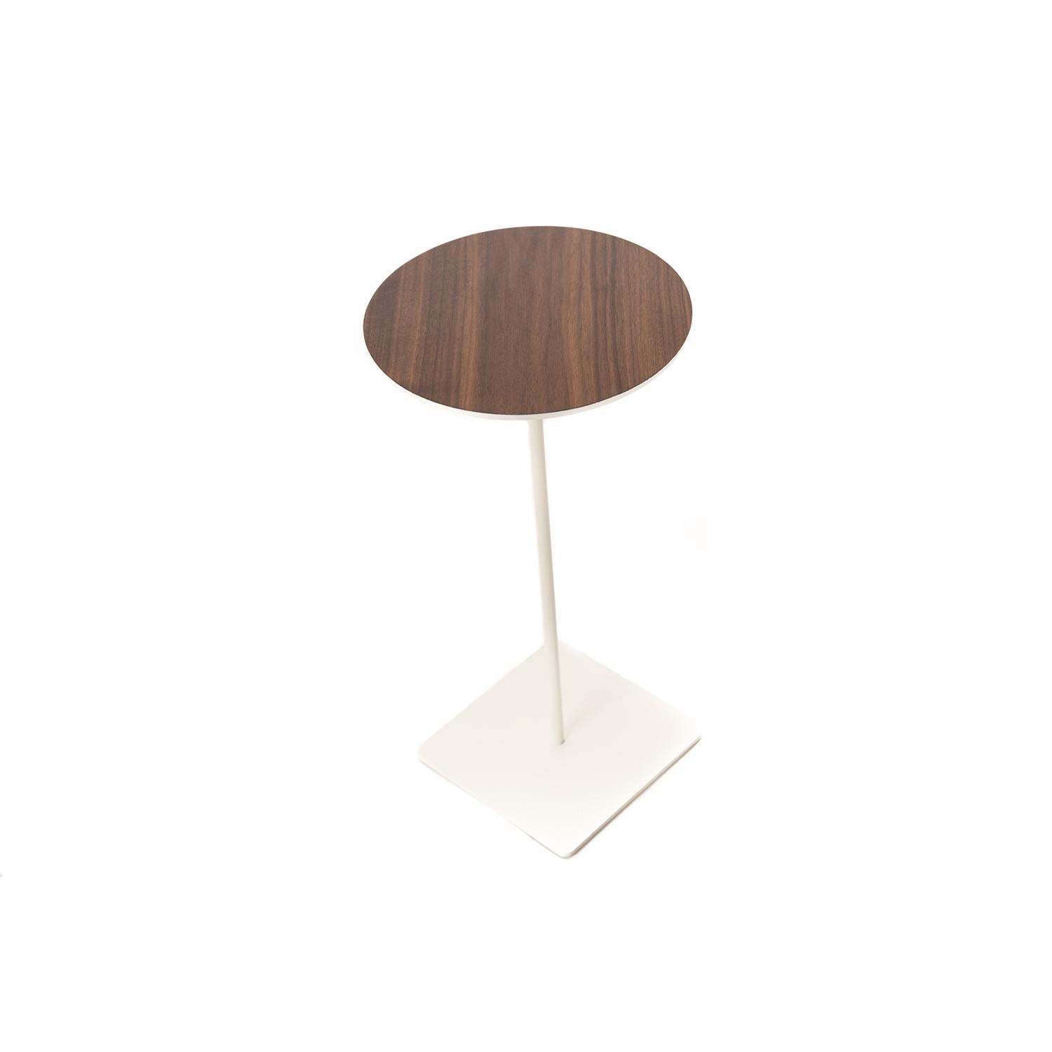 This round top walnut table sits upon a slender, white stem with a square base.