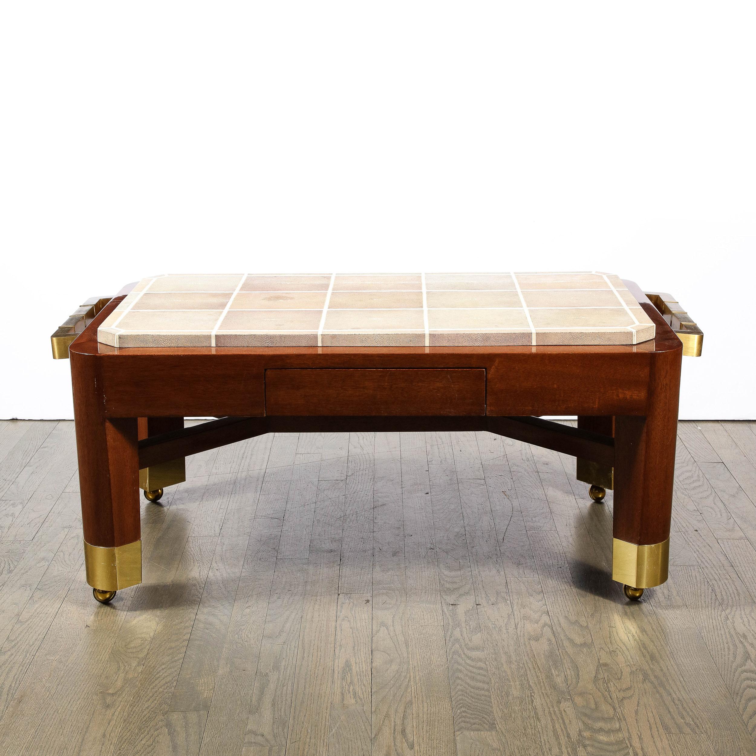 This stunning and dramatic modernist cocktail table was realized by the esteemed 20th century designer Lorin Marsh in the United States circa 1987. Sittings on brass castors, the piece offers cylindrical mahogany  legs capped in brass with a
