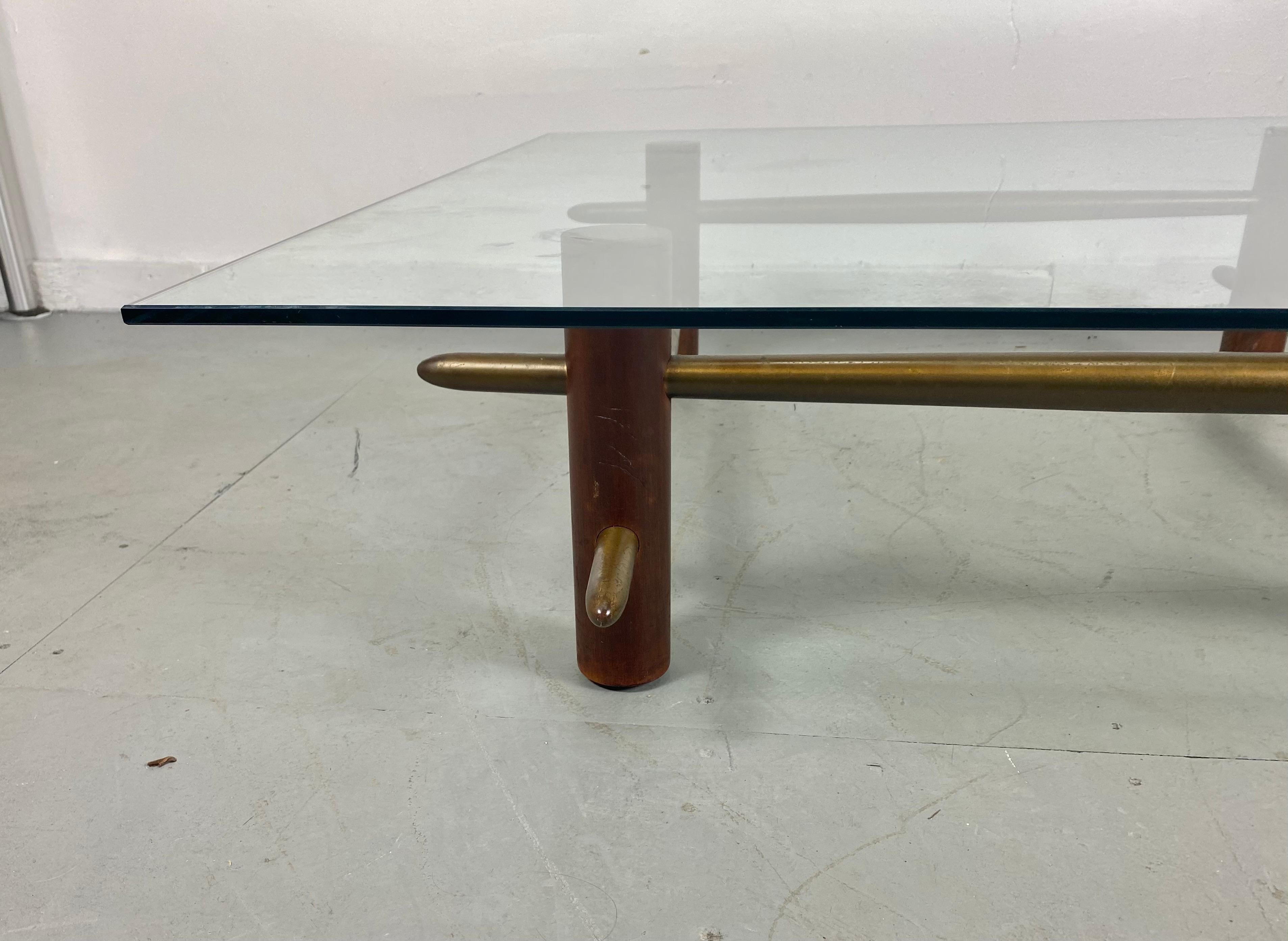Rare, early and important, coffee table designed by Robsjohn Gibbings for Widdicomb 1952, Model 1640. The base is comprised of solid mahogany pillars penetrated by solid brass bars. Base retains original finish /patina. solid brass bars can be