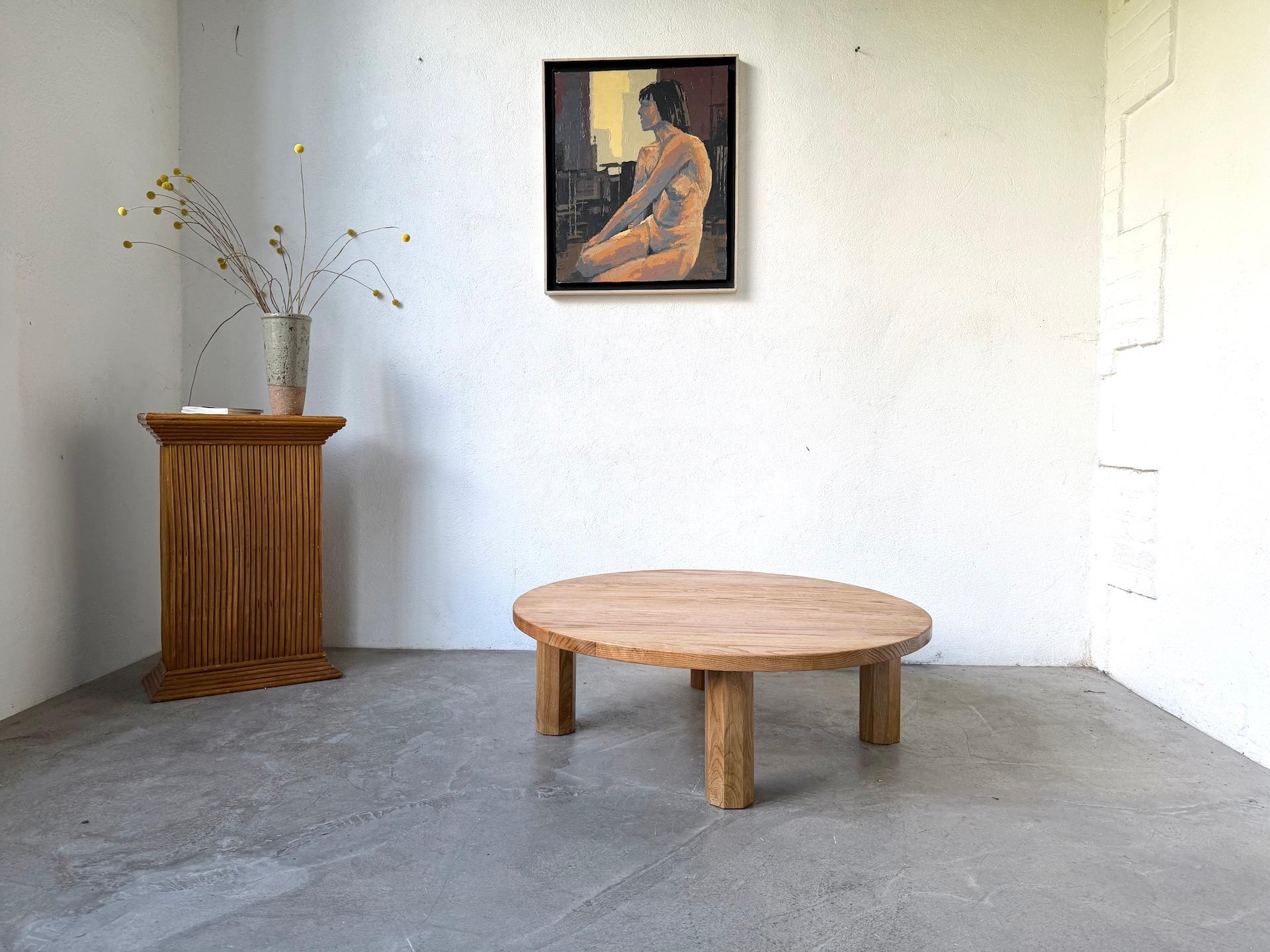 Table basse moderniste, années 1970, avec une base quadripode hexagonale. Entièrement réalisée en chêne massif, elle se distingue par son équilibre entre sobriété géométrique et présence sculpturale.

Le généreux plateau circulaire associé à des