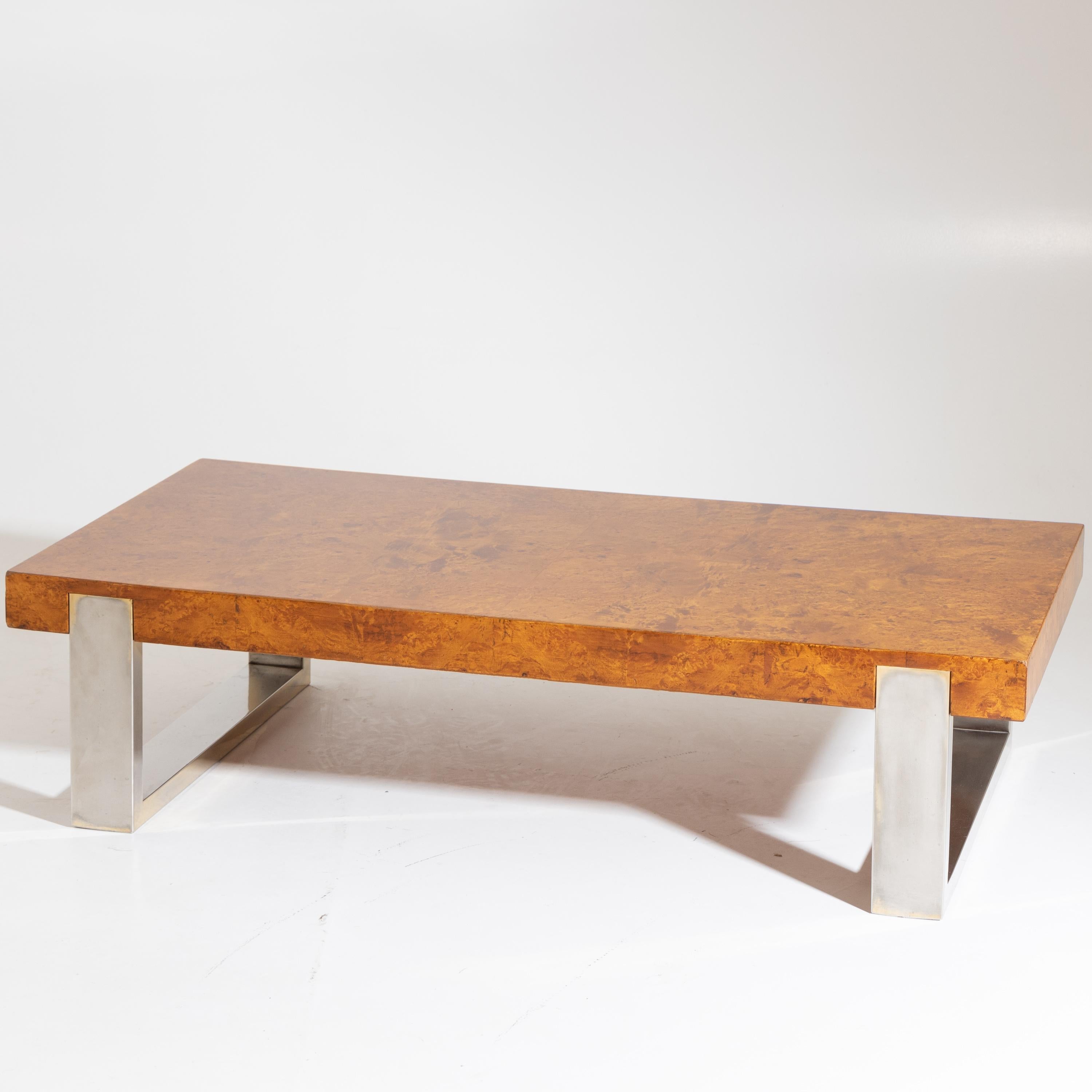 Coffee table standing on u-shaped metal supports with a thick rectangular tabletop, veneered in poplar burl.