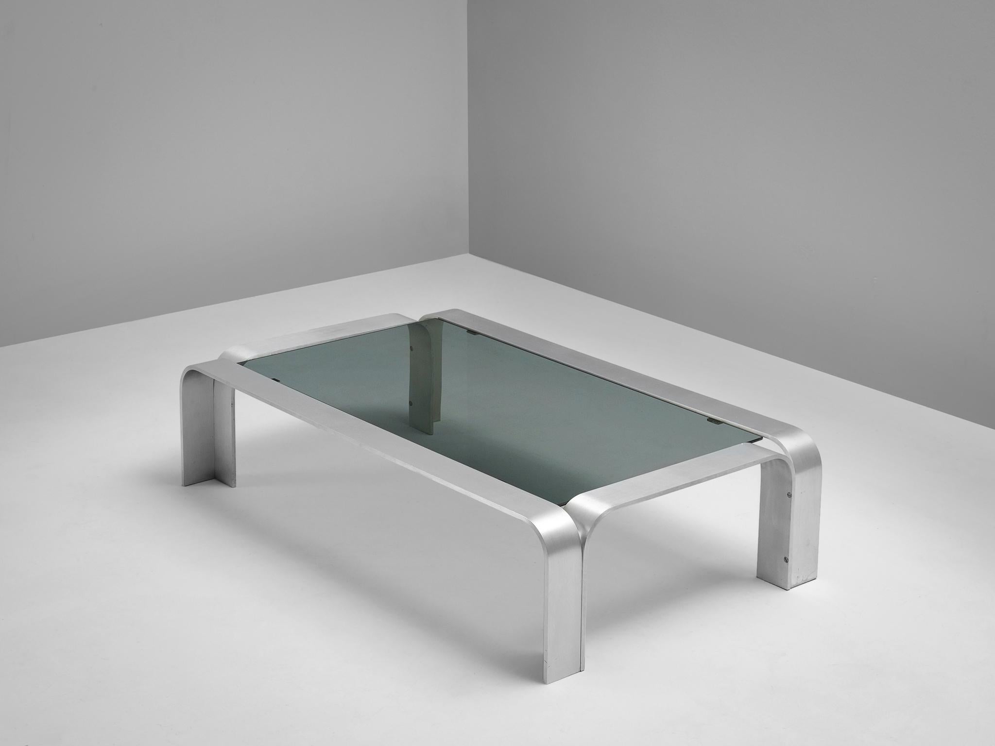 Coffee table, aluminum and glass, European, 1970s.

Elegant modernist coffee table. The rectangular table is accompanied by a dark glass top. The aluminum frame consist of four bended arches. The frame is manufactured from metal strips and rounded