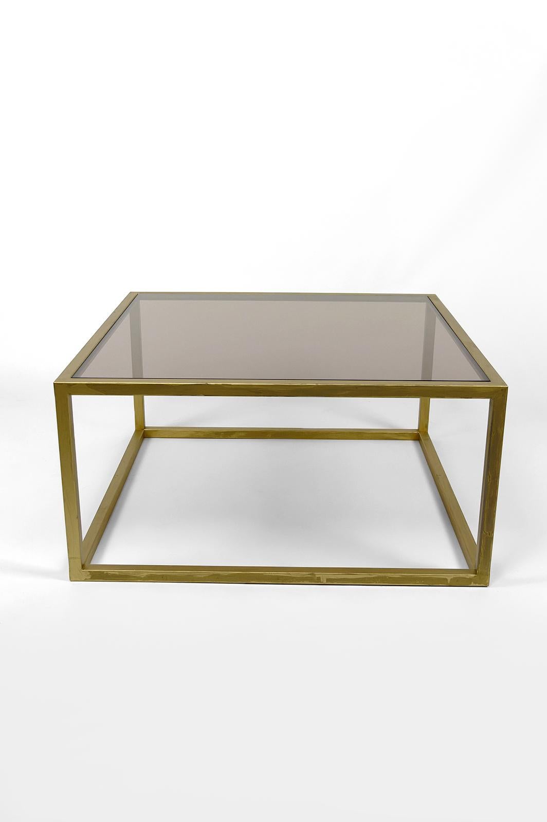 Coffee table in gold painted metal and smoked safety glass top.
France, Circa 1970

Dimensions:
height 40 cm
width 80 cm
depth 80 cm