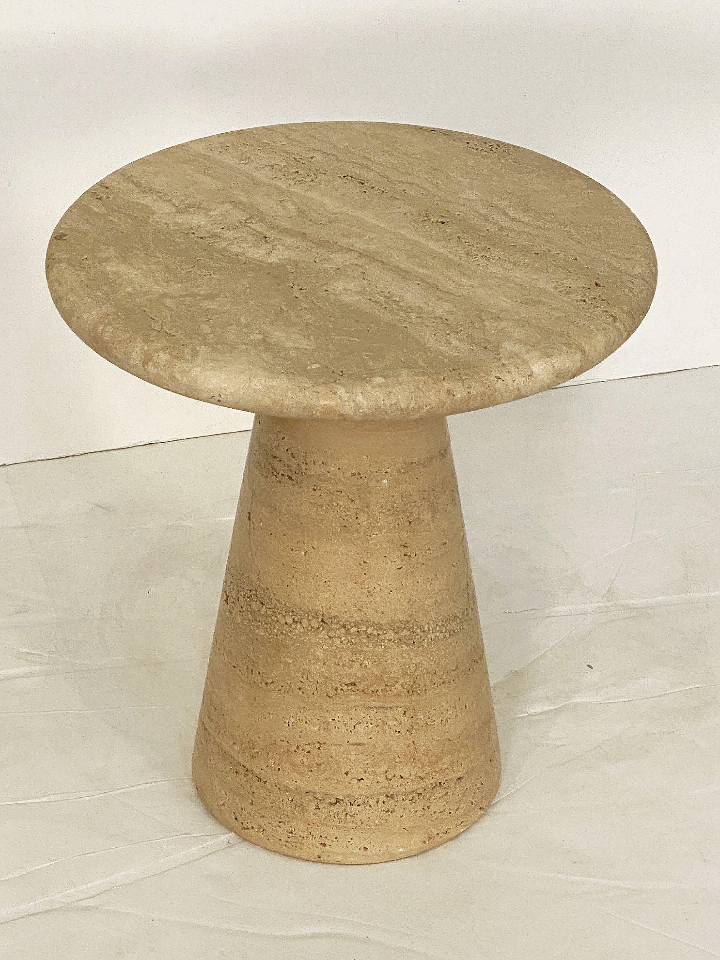 A fine Italian side or end table of travertine stone, featuring a circular top attached to a conical-shaped base in a style reminiscent of the Modernist designs of Angelo Mangiarotti.

There are four tables available and each can be displayed