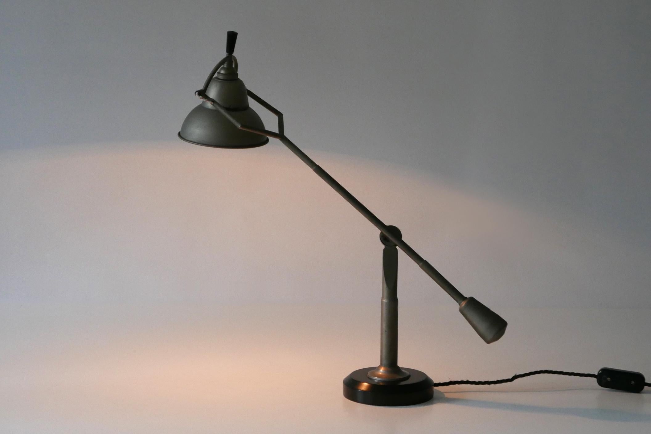 Iconic Art Deco counterbalance table lamp or desk light. Designed by Édouard-Wilfred Buquet, 1927, France. This example must have been produced in 1960s-1970s in Munich, Germany. Quality work. Metal label to underside.

The lamp comes with an extra