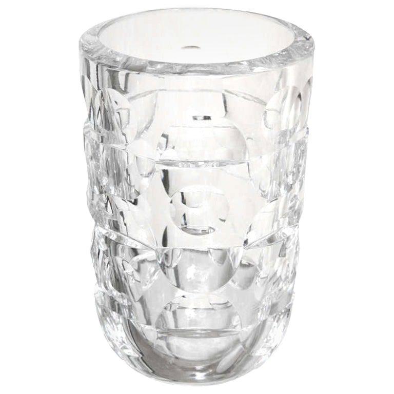 Ce lourd vase en cristal Orrefors, signé et de style moderniste, présente des motifs alternés de demi-cercles et de cercles pleins incisés. Il est signé Mona Morales Schildt. Elle est élégante et moderne, et parfaite pour vos fleurs préférées !