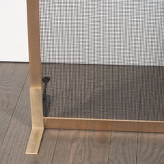 Pantalla de chimenea modernista hecha a medida en latón cepillado con rejilla de malla de hierro