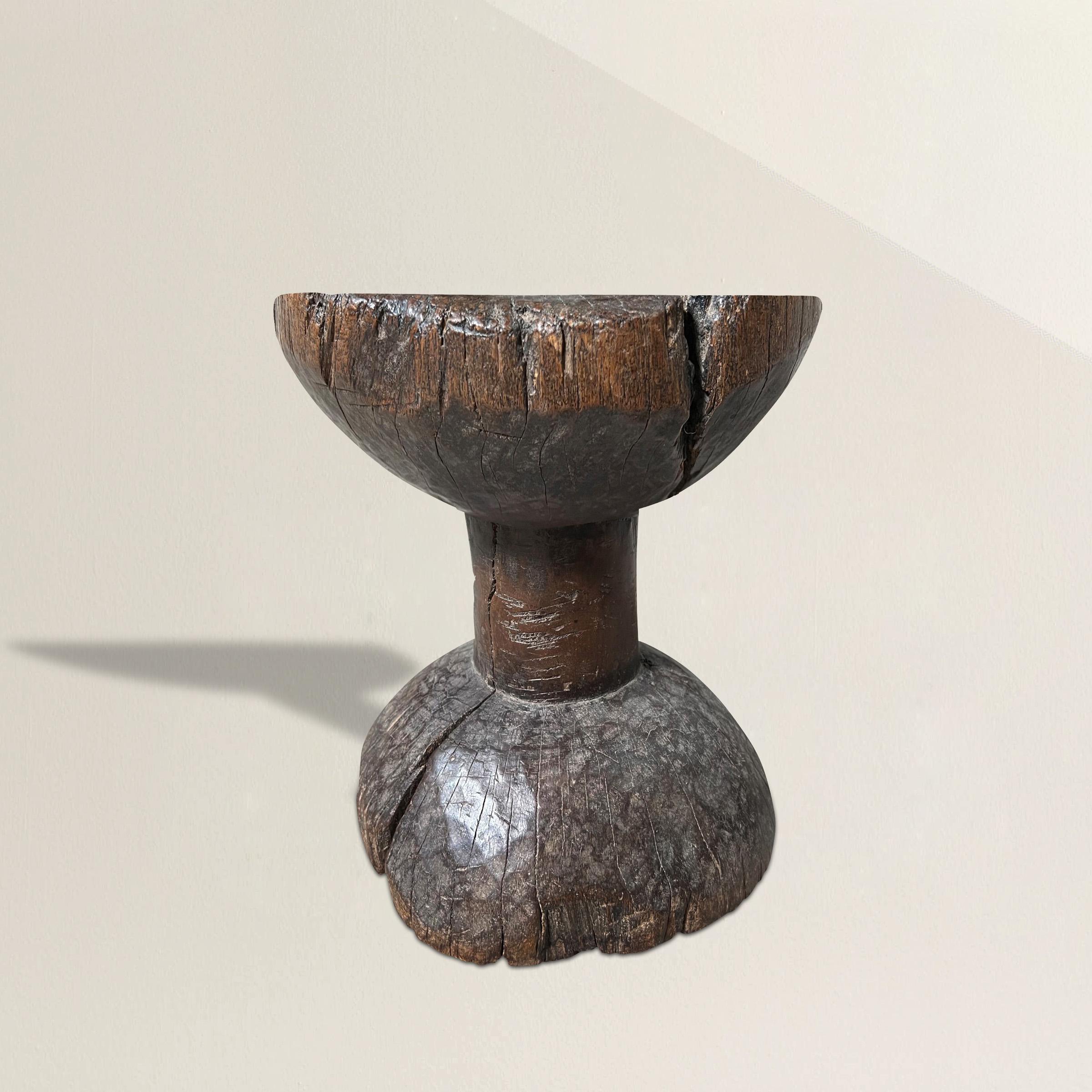 A chic modernist early 20th century Dan Peoples stool from Ivory Coast, carved from one piece of wood with a simple hourglass form, and the most wonderful patina only time could bestow. The perfect stool, or drinks table next to your favorite