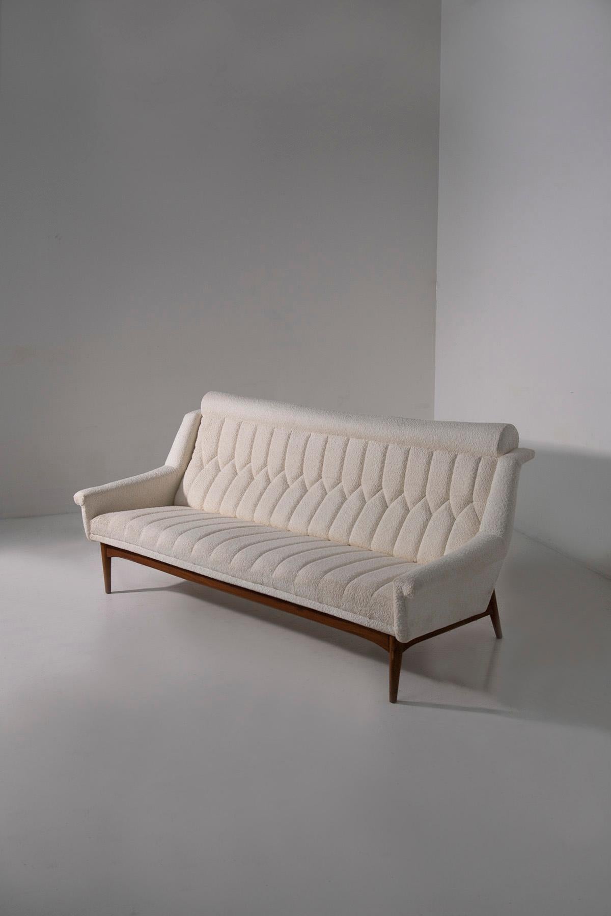 Step into the enchanting world of mid-century elegance with this exquisite Danish modernist sofa hailing from the 1950s. It embodies the quintessential forms of European Nordic design, each curve and angle a testament to the era's refined aesthetic