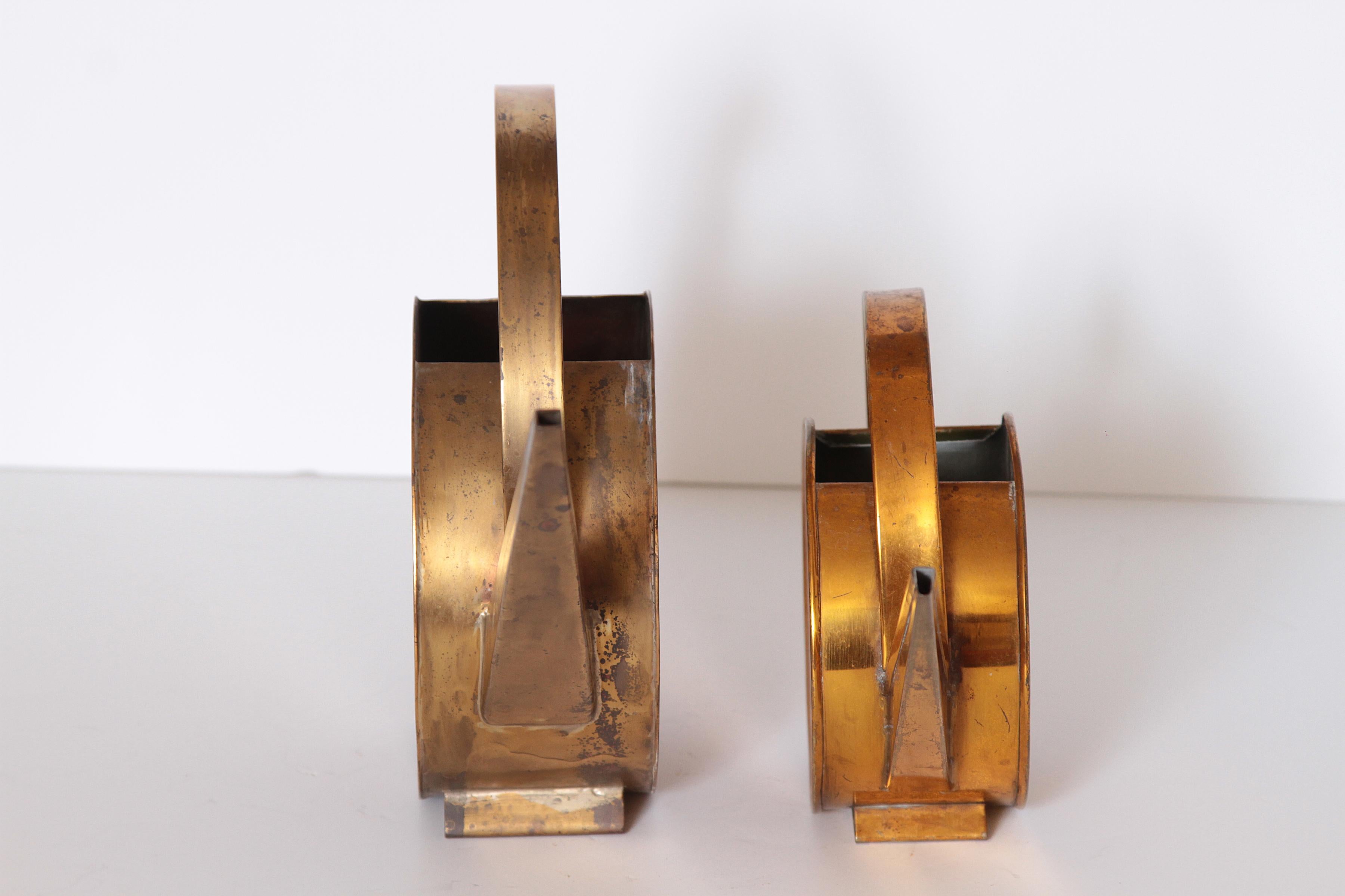 Modernist design 20th century brass watering cans, Bauhaus influenced. 

Very large hand-wrought 20th century brass watering can. Heavy solid brass or plated copper construction. 
Second matching smaller can in more of a plated tin or the like.