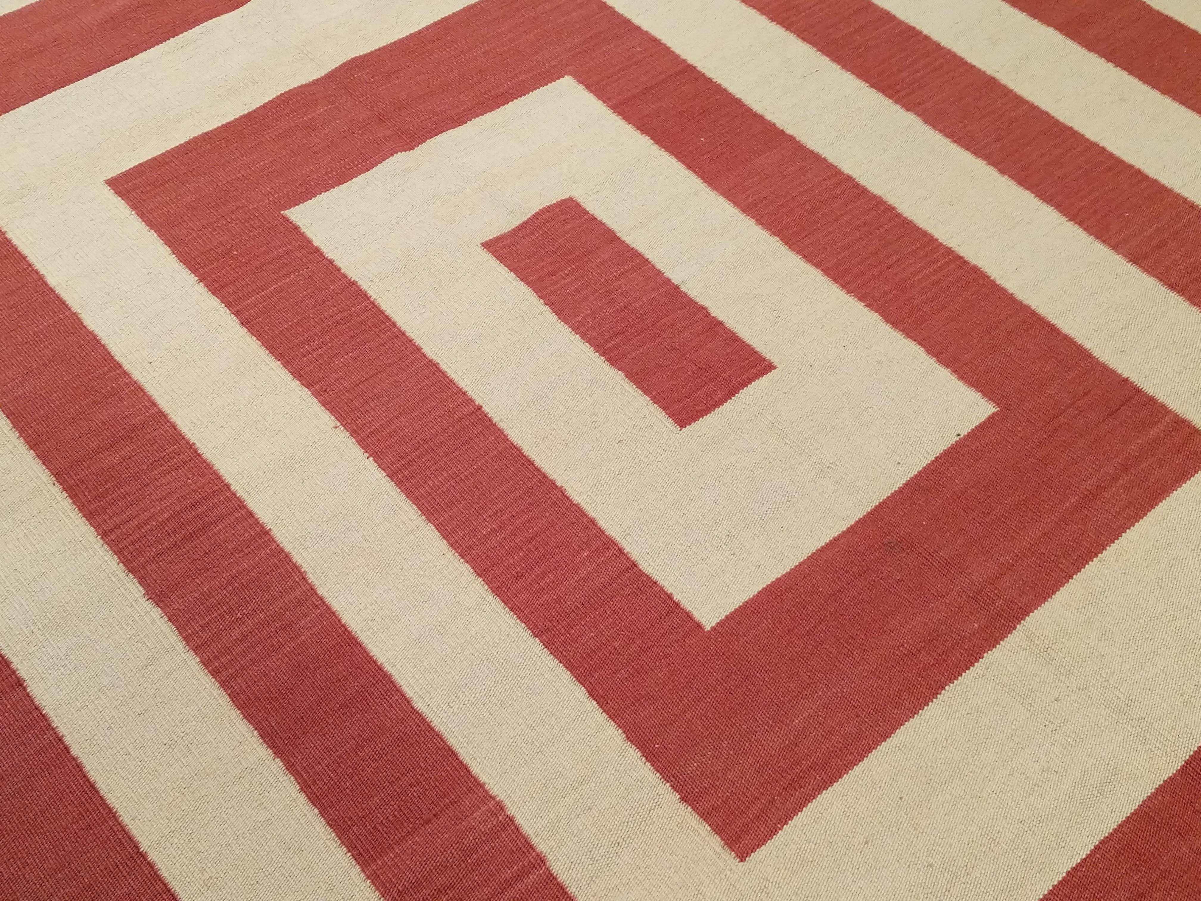 Inspired by the highly visual patterns developed by Modernist movements such as Op-Art, this wool flat-weave has a pattern of red concentric rectangles on an ivory background. Part of our collections of contemporary kilims, this design can be