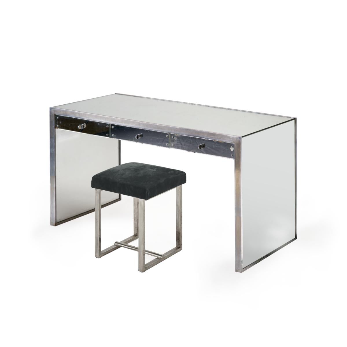 Modernist flat-surface desk with rectangular mirrored glass side-panels; edges clad with nickel-coated steel edge.
Three drawers inserted under the tabletop.
Complete with it's original stool in nickel plated steel.
Model identical to the one