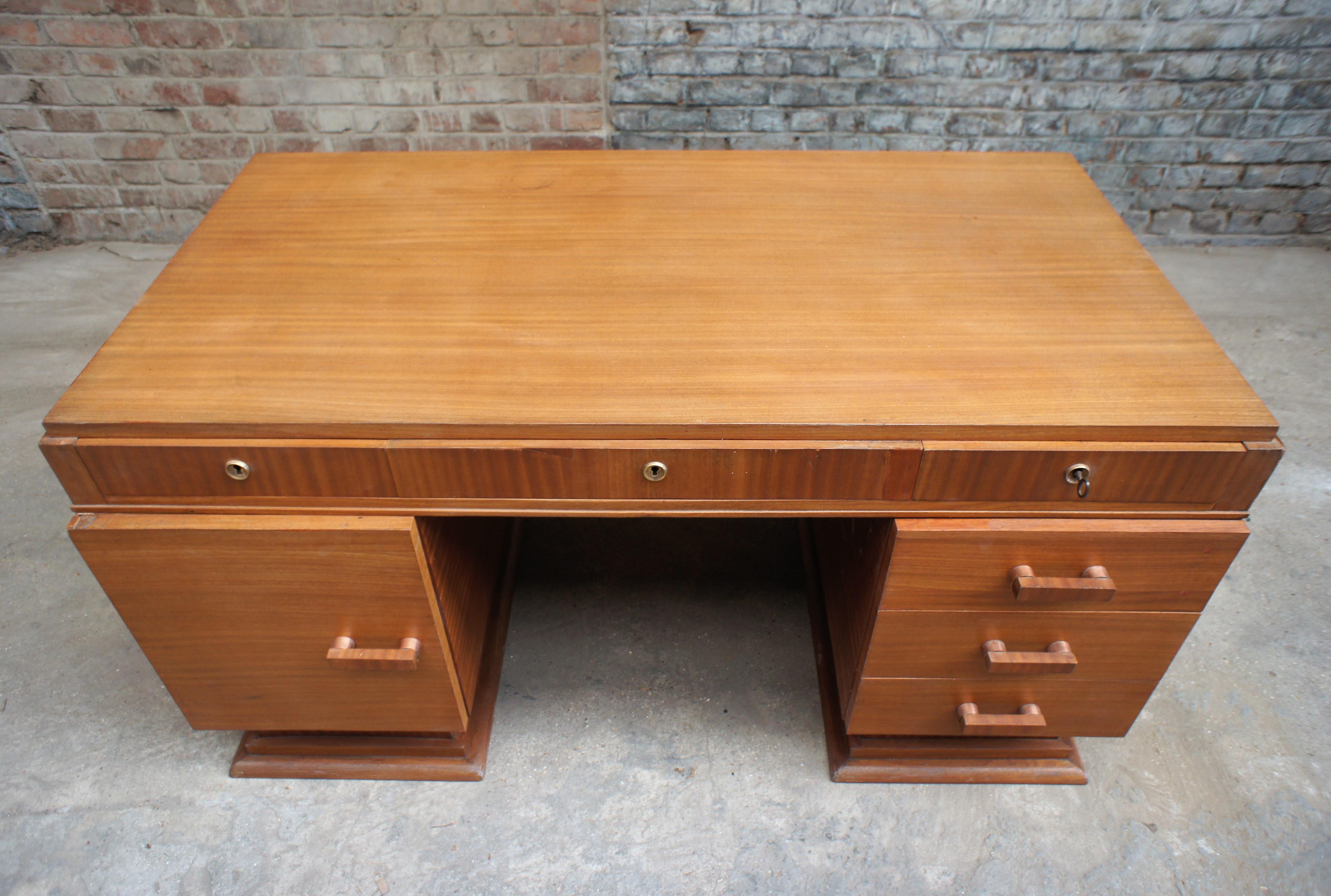 Art Deco desk in blond mahogany veneer, it has two boxes, one opening with a door revealing 4 sliding storage shelves, the other three drawers, three other drawers are present under the top. This office has its key, it was restored three years ago.