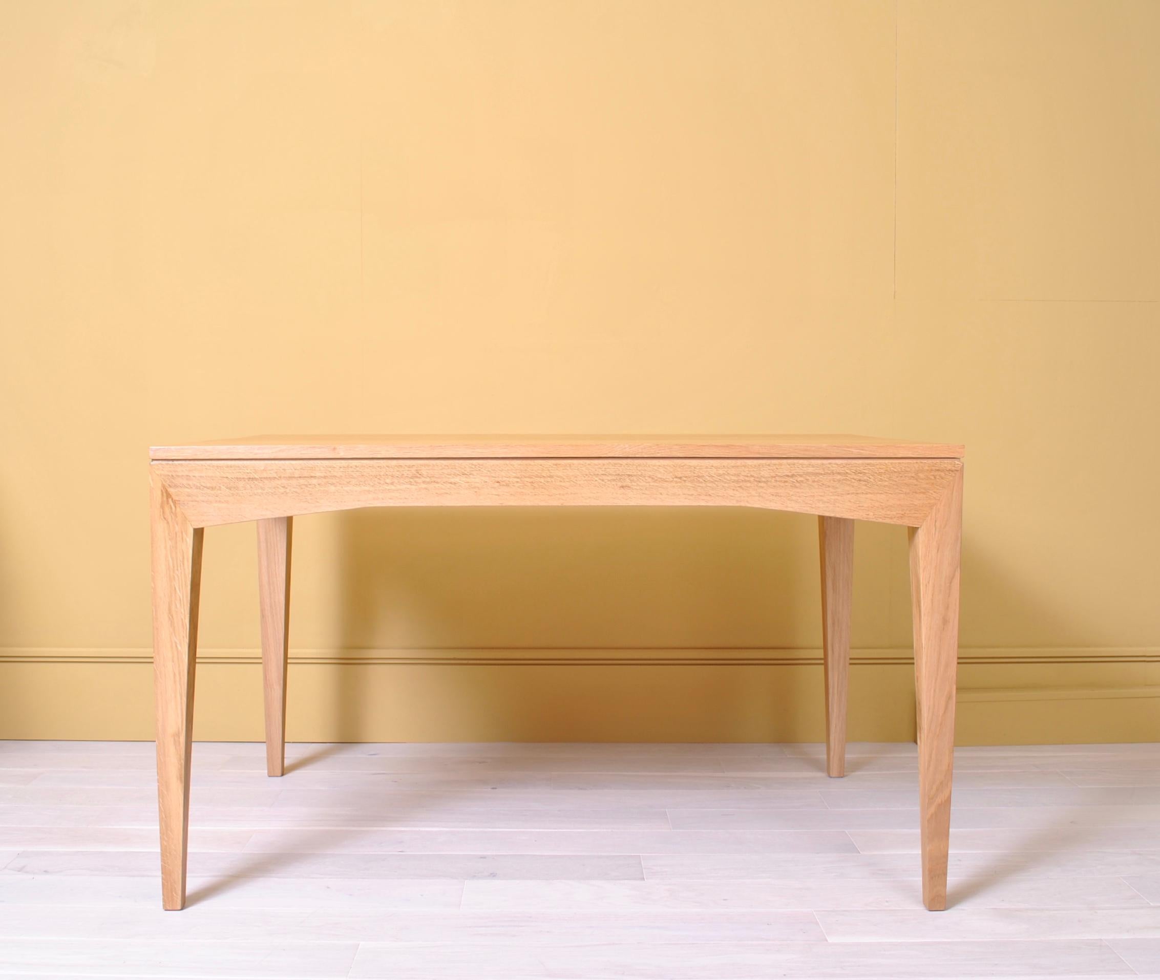 A sleek handmade English modernist desk or writing table. Constructed with a traditional 3 wide solid board surface on beautifully visible acute angled leg and frame. Handcrafted by traditional furniture craftsmen in England from fully Quarter sawn