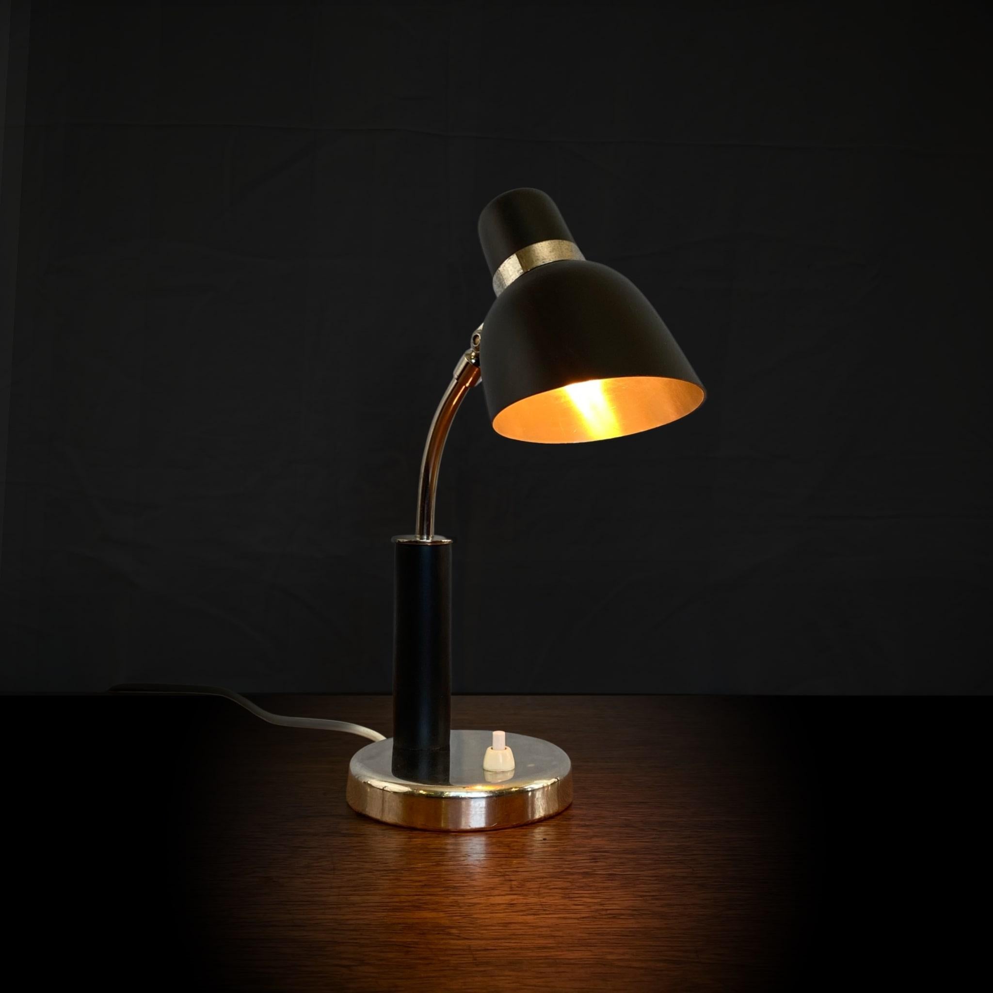 Petite lampe de table, faisant également office d'applique, produite par le département éclairage du grand magasin suédois Nordiska Kompaniet dans les années 1930, peut-être conçue par Erik Tidstrand. Fabriqué en acier et en métal chromé avec des