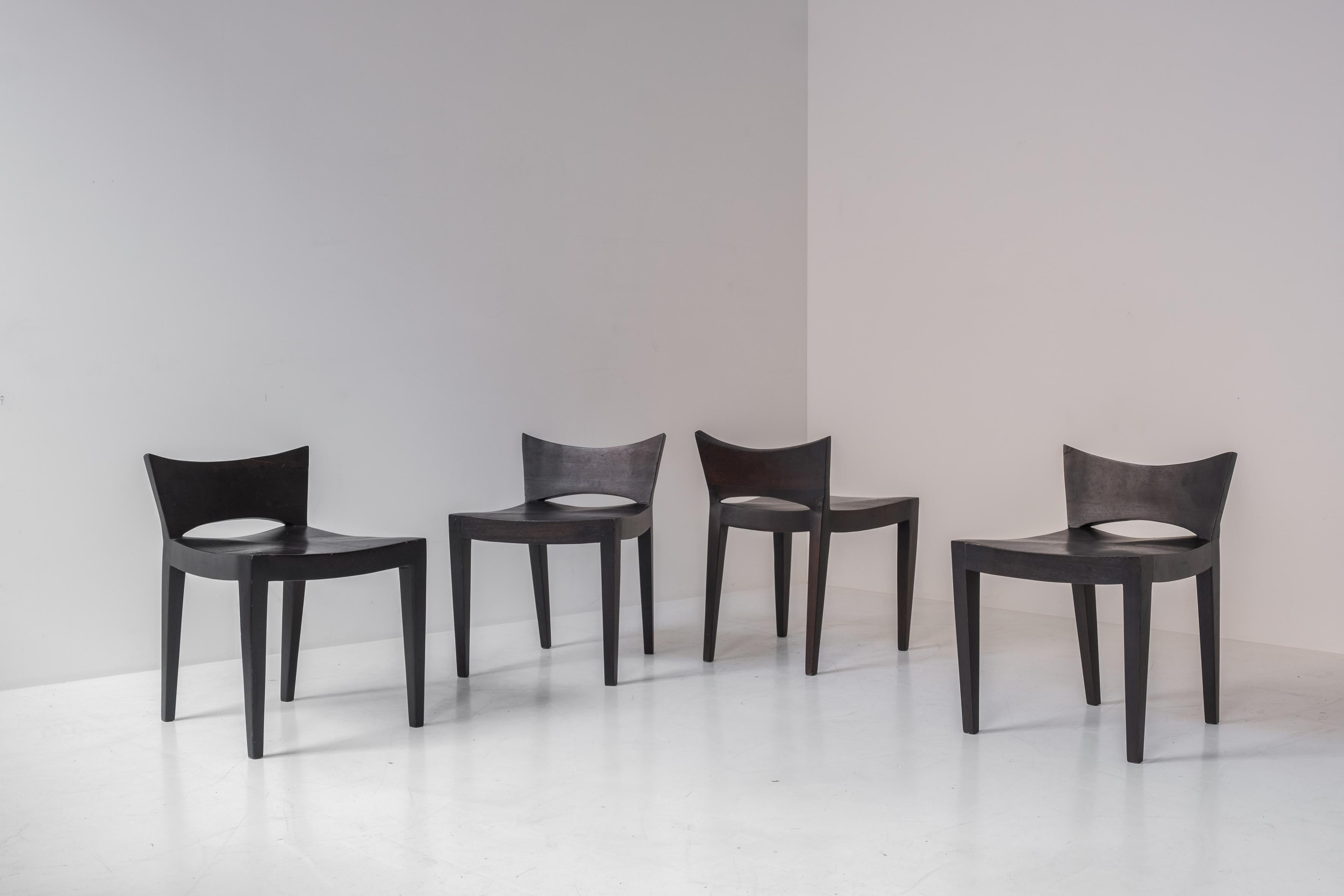 Exceptionnel ensemble de quatre chaises de salle à manger modernistes en chêne teinté provenant de France, datant des années 1960. Ces chaises ont un dossier bas inhabituel qui confère à ces pièces une esthétique saisissante. Présenté dans un bon
