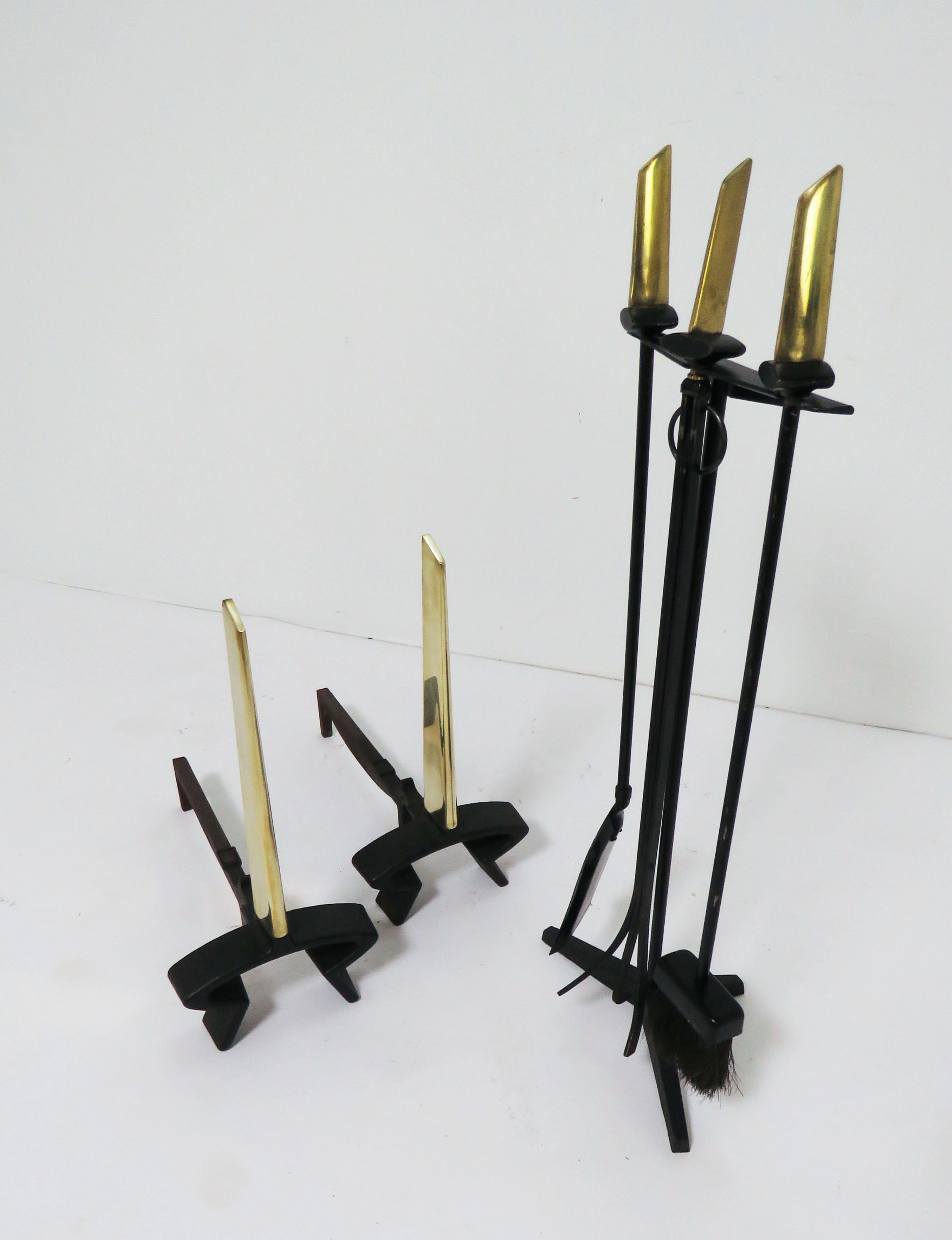 Classic pair of modernist andirons in solid brass and forged iron with matching fireplace tools (on tripod base with solid brass handles) designed by Donald Deskey for Bennett, circa 1950s.

Andirons measure 19.25