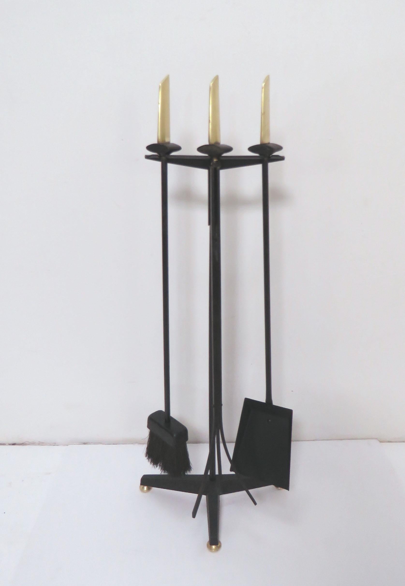 Elegant set of modernist fireplace tools with handles in solid brass and iron, designed by Donald Deskey for Bennett, circa 1950s.