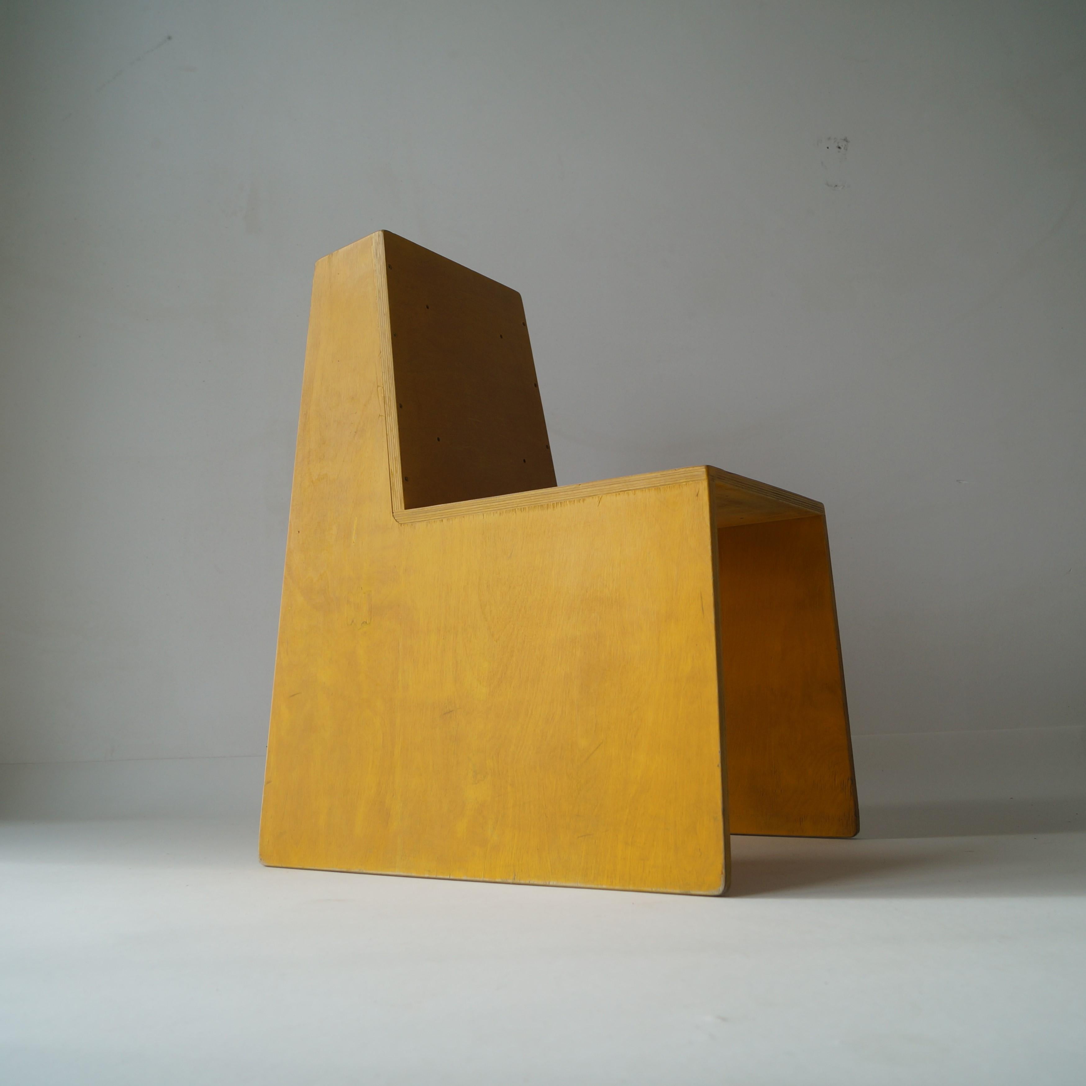 A yellow stained plywood modernist side or accent chair with a cubist, architectural appearance. The designer was an architect who made a series of around 60 of these chairs, unfortunately his name is unknown. The design of the chair has been