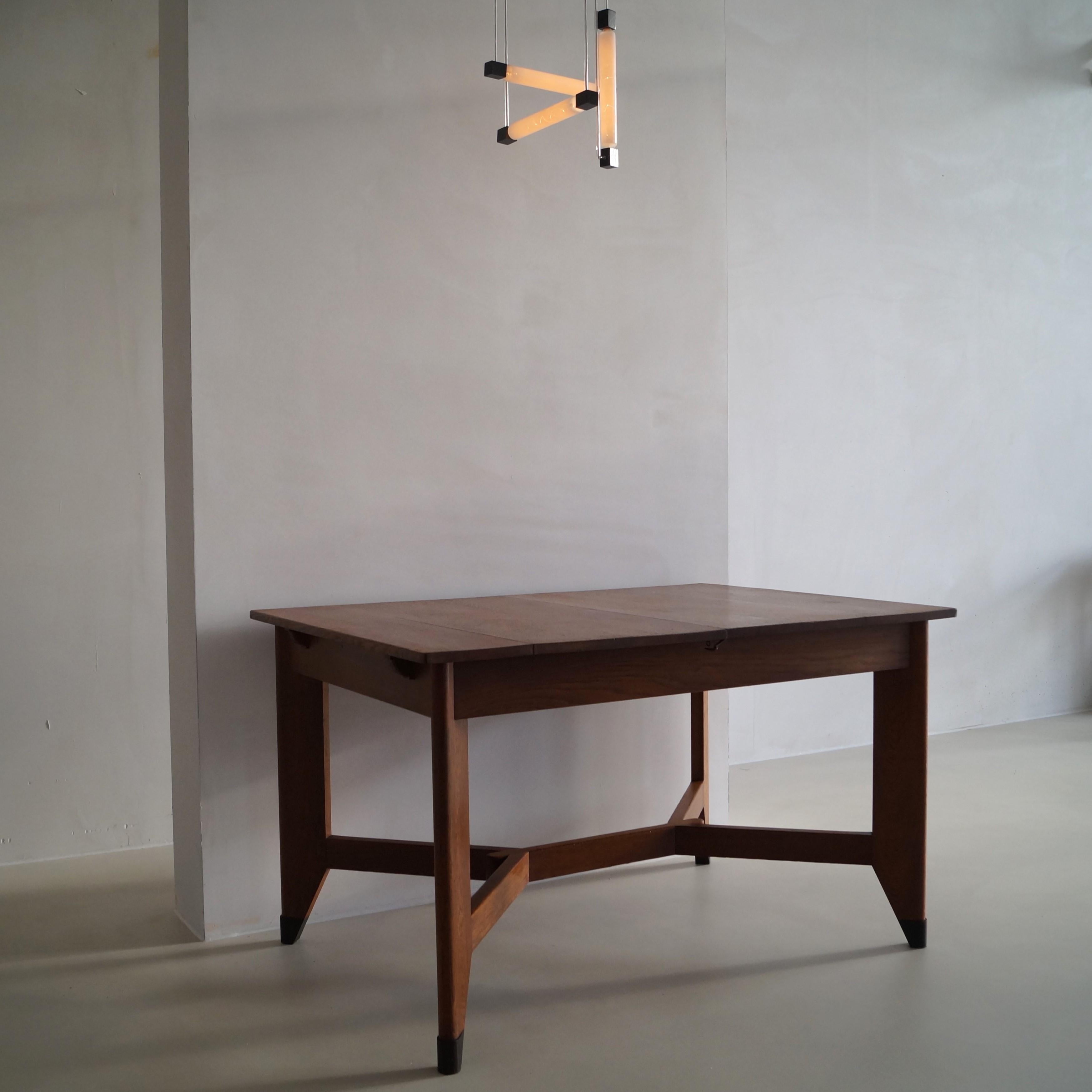 An early, more luxurious and very rare version of the extendable dining table by Hendrik Wouda for Pander. The difference is a more elaborate design of the tablelegs - each tableleg is made from thicker, on the outer sides rounded oak and has a