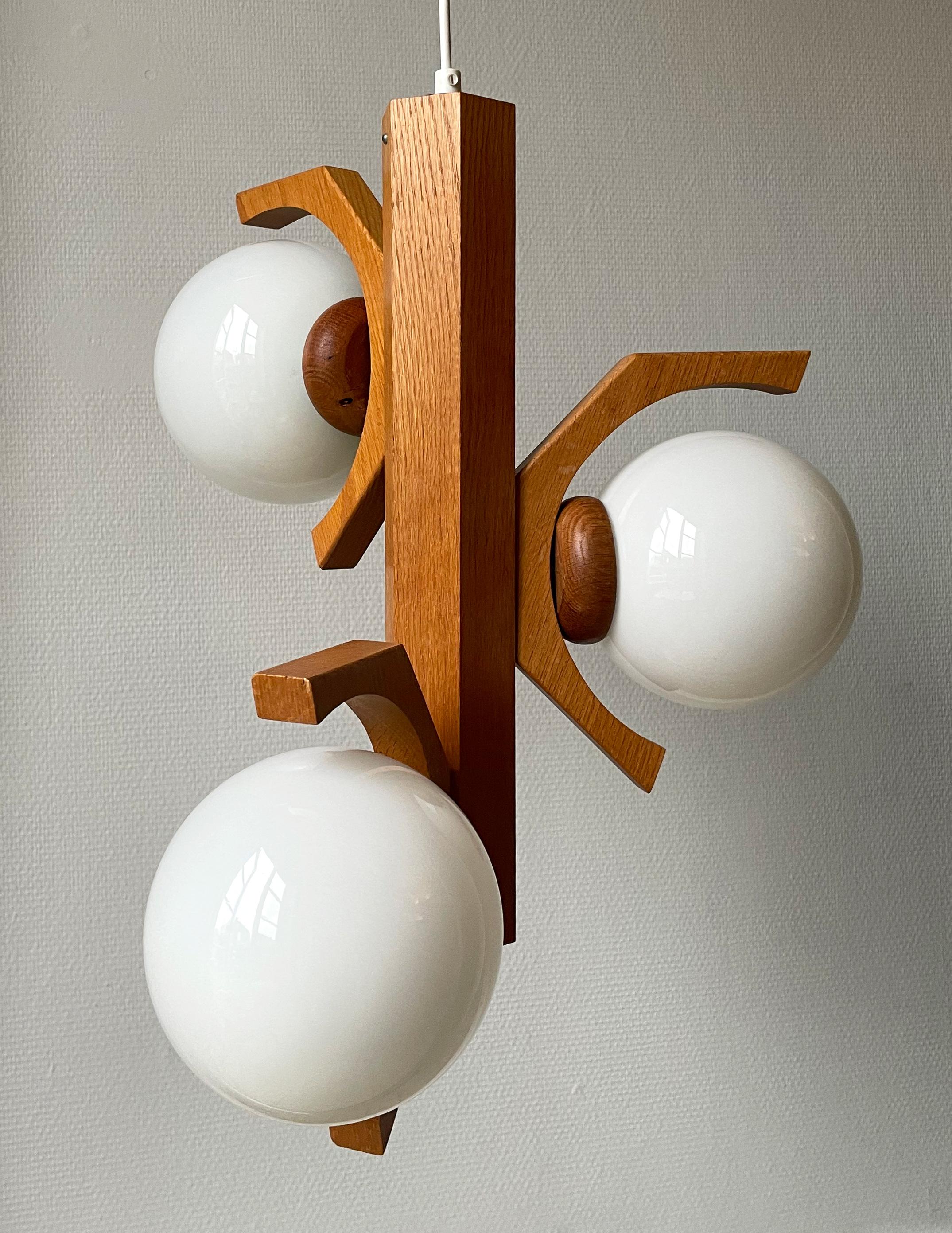 Vintage organic modern sculptural chandelier. Oak wood mount with three arms holding three milky white glass globes. Manufactured by Bony Design in the Netherlands in the early 1970s. Rewired and in great vintage condition with few signs of wear on