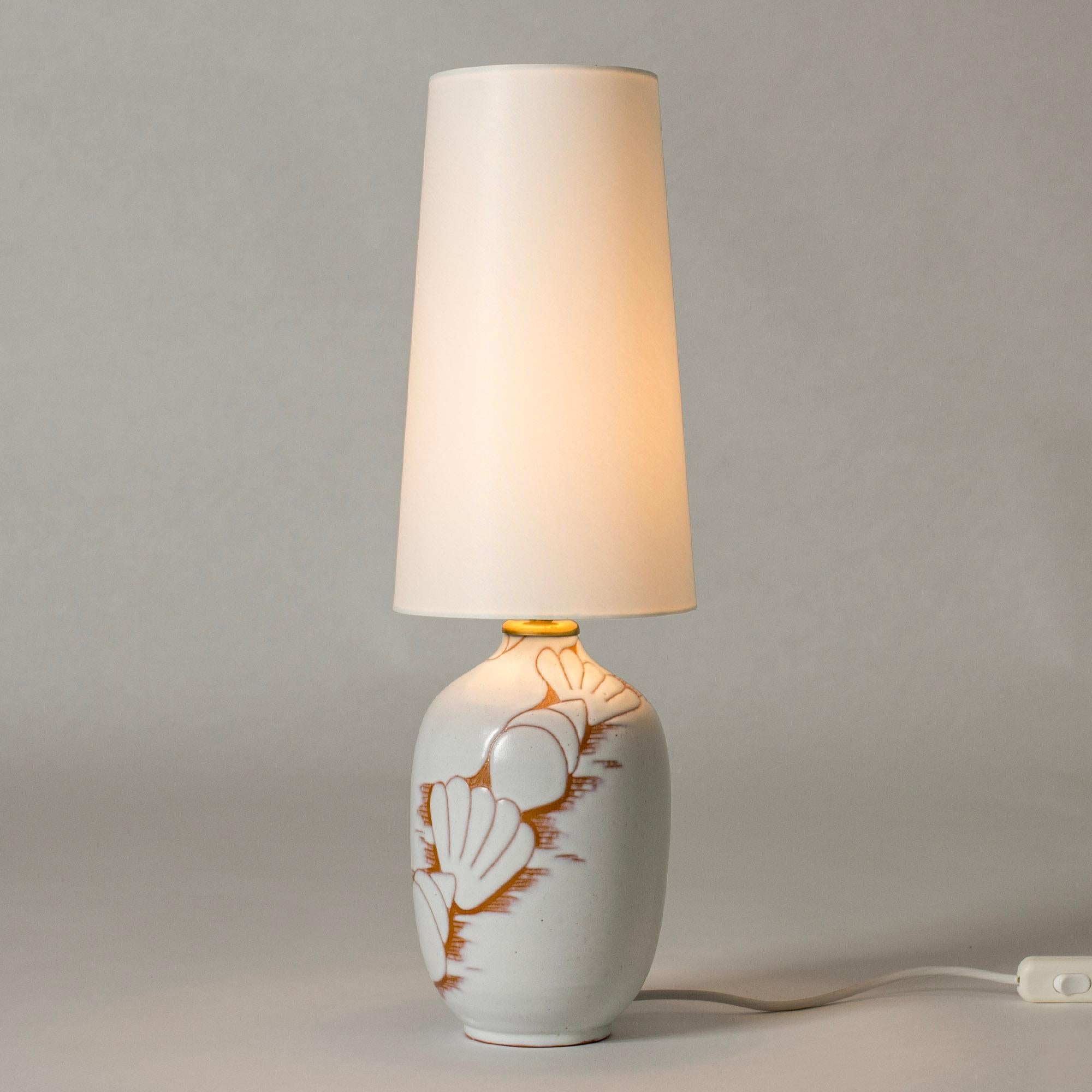 Lovely earthenware table lamp by Anna-Lisa Thomson, glazed white over an elegant decor of shells.

The artist Anna-Lisa Thomson is best known for her stoneware and earthenware for Upsala-Ekeby where she worked from the mid 1930s until her untimely