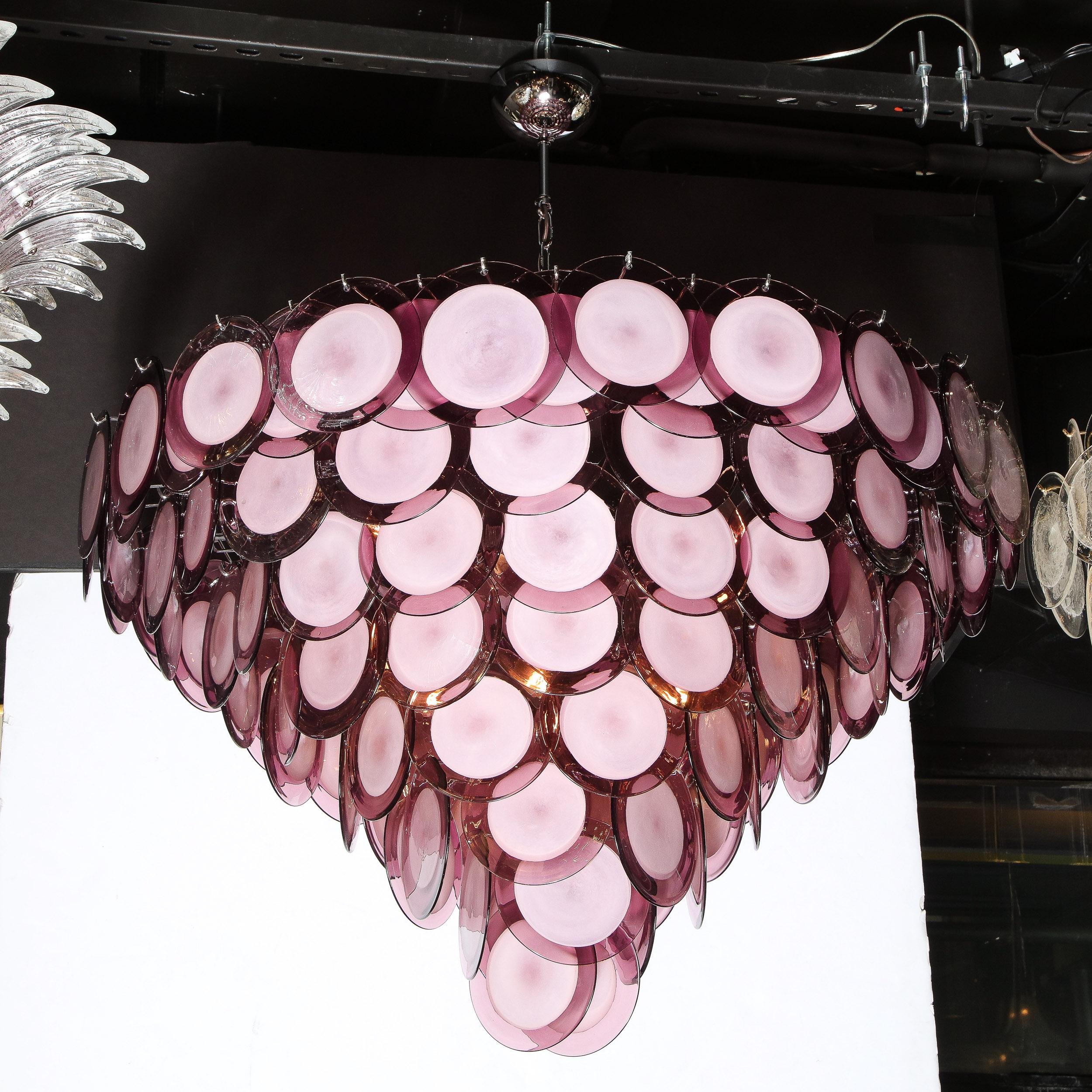 This stunning modernist chandelier was realized in Murano, Italy- the island off the coast of Venice renowned for centuries for its superlative glass production. It features a conical body composed of an abundance of handblown Murano circular shades