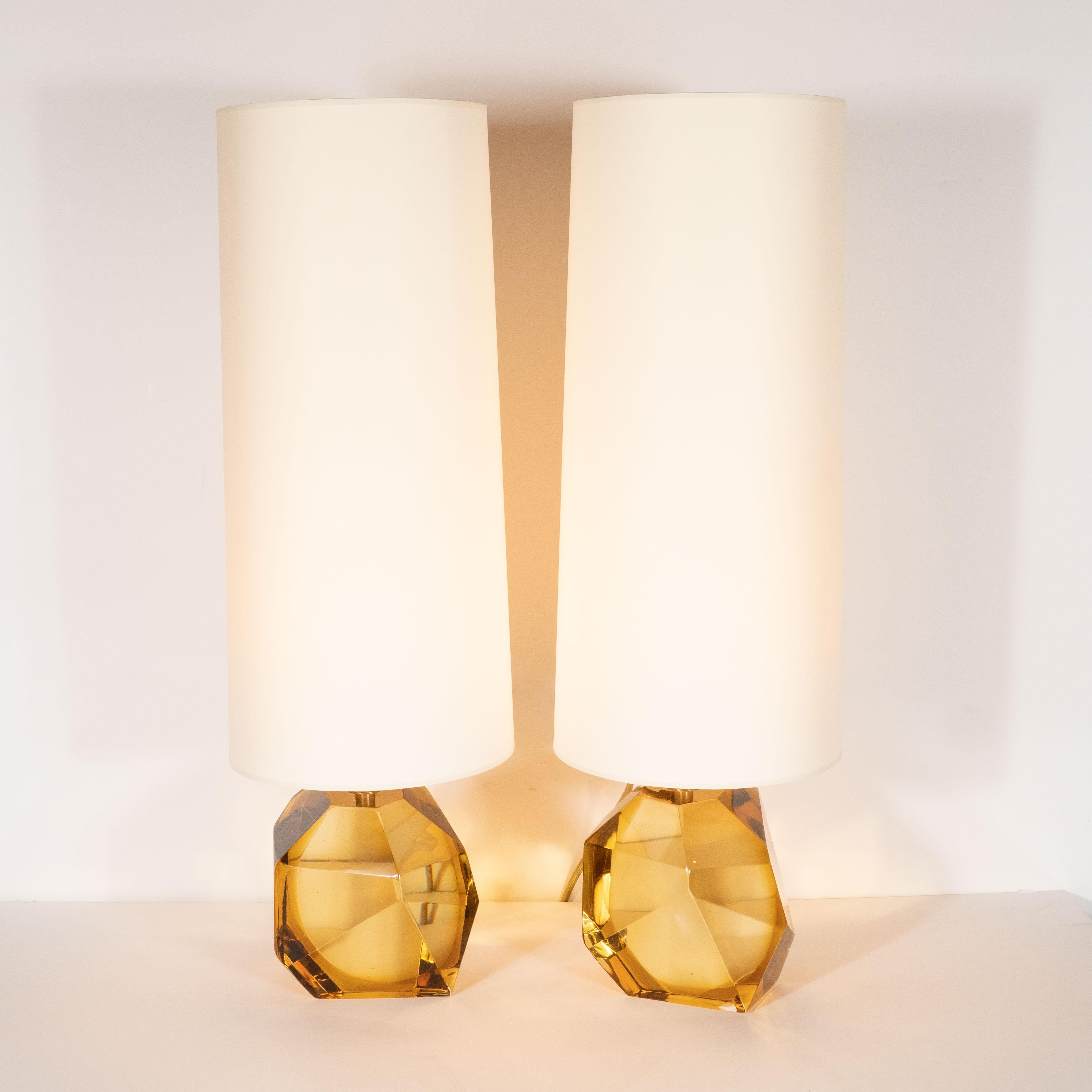 This stunning pair of table lamps were handblown in Murano, Italy- the islands off the coast of Venice renowned for centuries for their superlative glass production. They feature faceted bodies realized in handblown translucent Murano glass in a