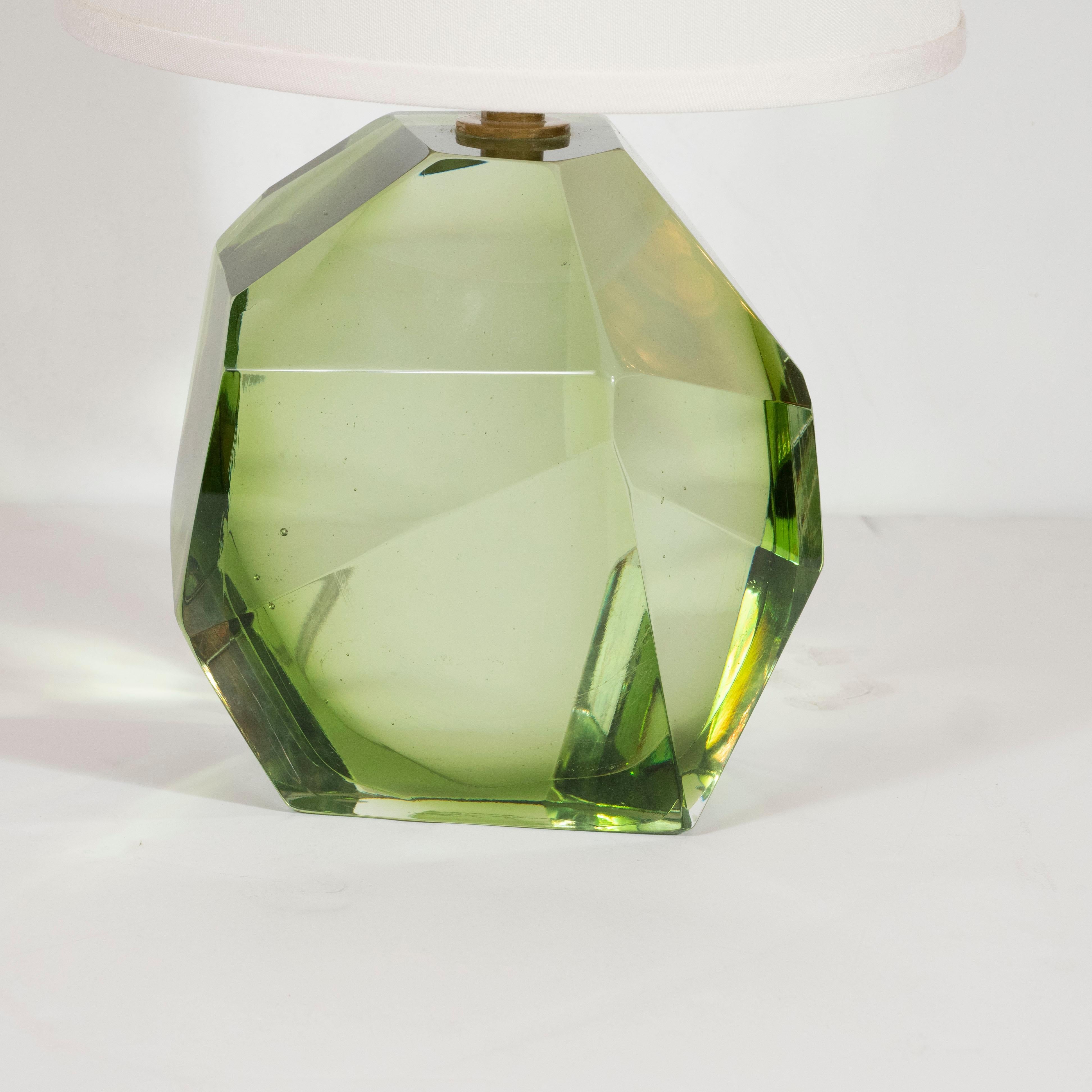 This stunning and elegant table lamp was realized in Murano, Italy- the island off the coast of Venice renowned for centuries for its superlative glass production. It features a faceted Murano glass body- resembling an oversized cut gemstone- in a