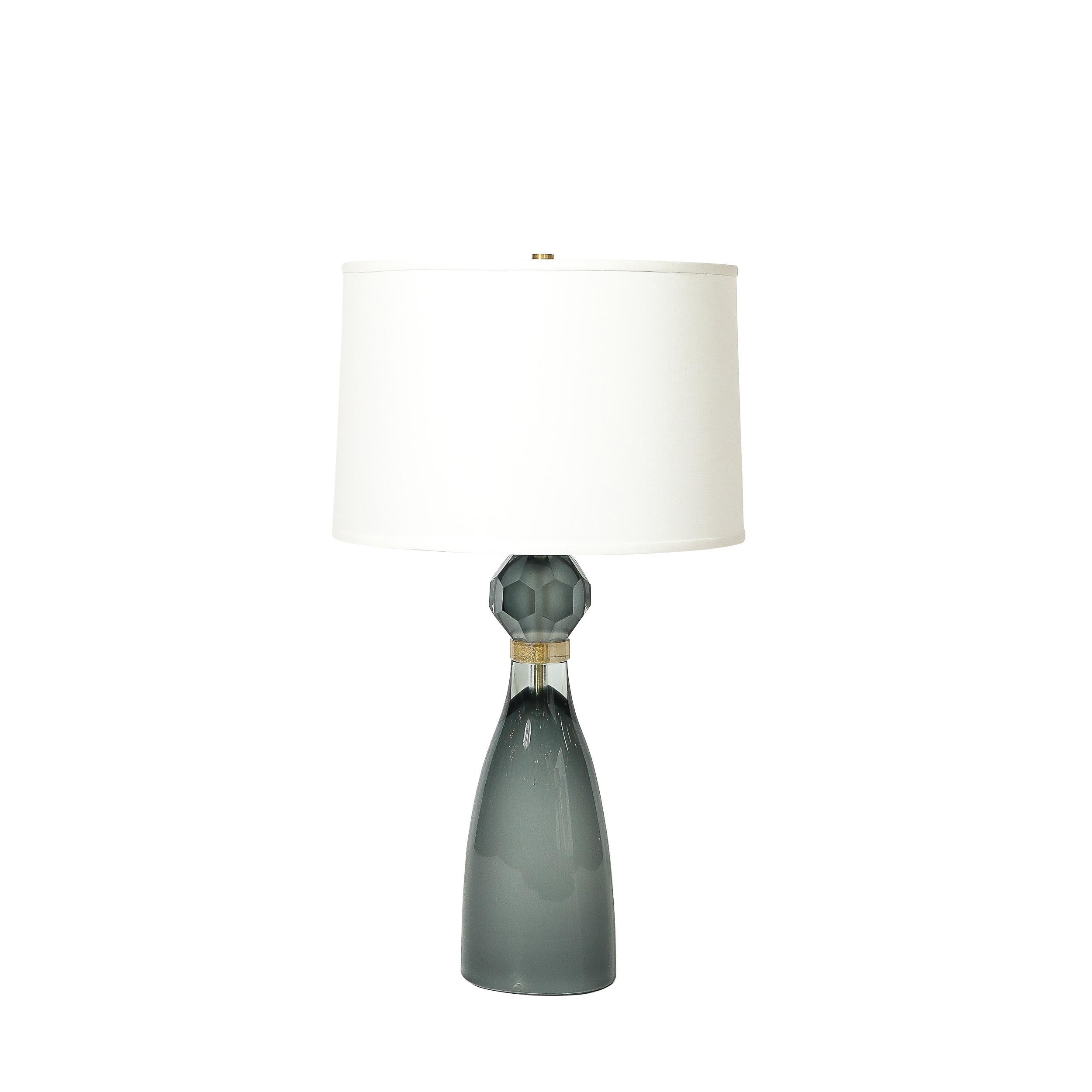 A stunning pair of Modernist table lamps, crafted in Italy in the 21st century, showcasing the unparalleled artistry and technical mastery of Murano glassmakers. These lamps feature hand-blown Murano glass in an elegant hourglass form, designed to