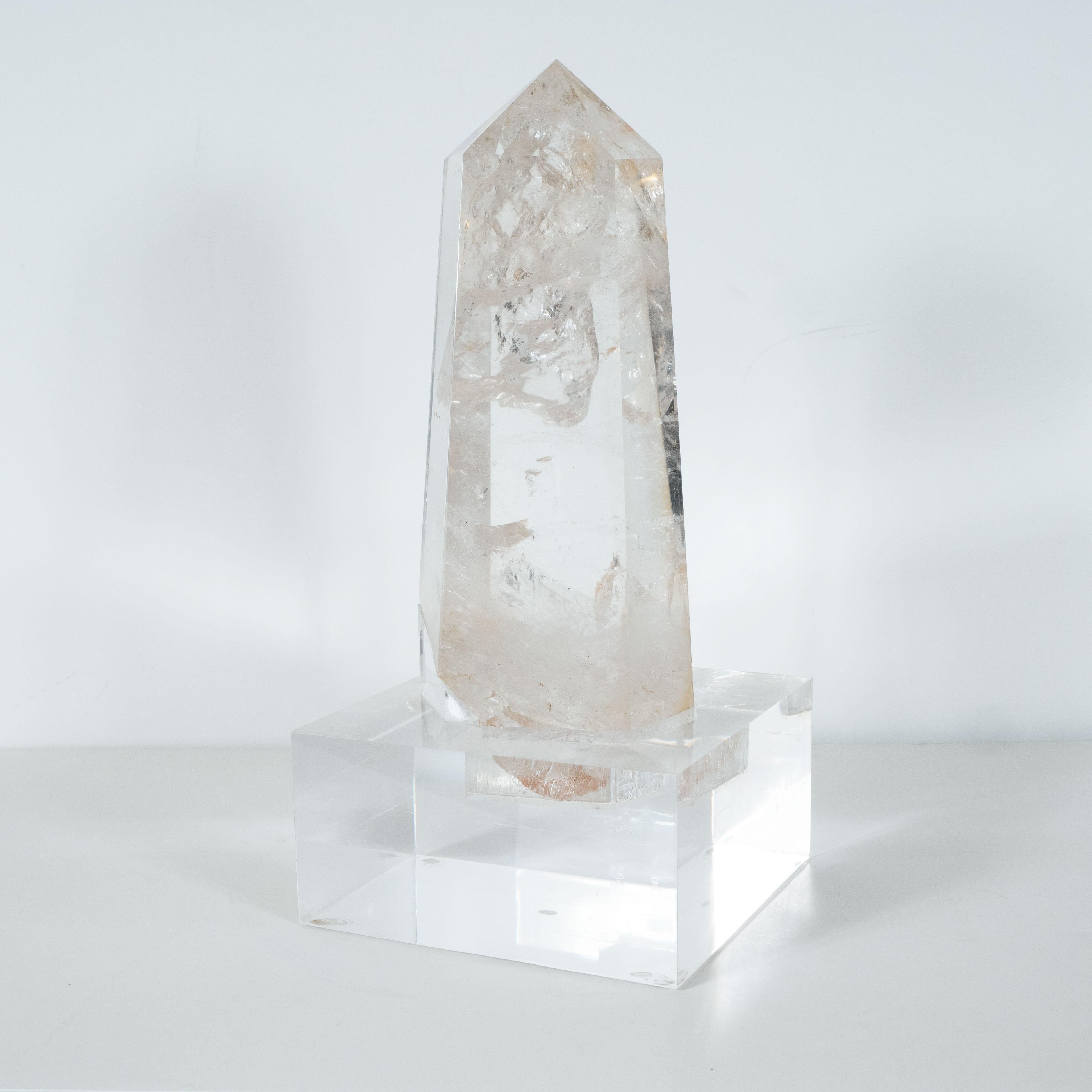 This elegant modernist rock crystal obelisk was produced in Brazil, where many of the finest specimens of this kind are sourced. It features a faceted body with a wealth of organic textures apparent in its interior. The specimen rests in a custom
