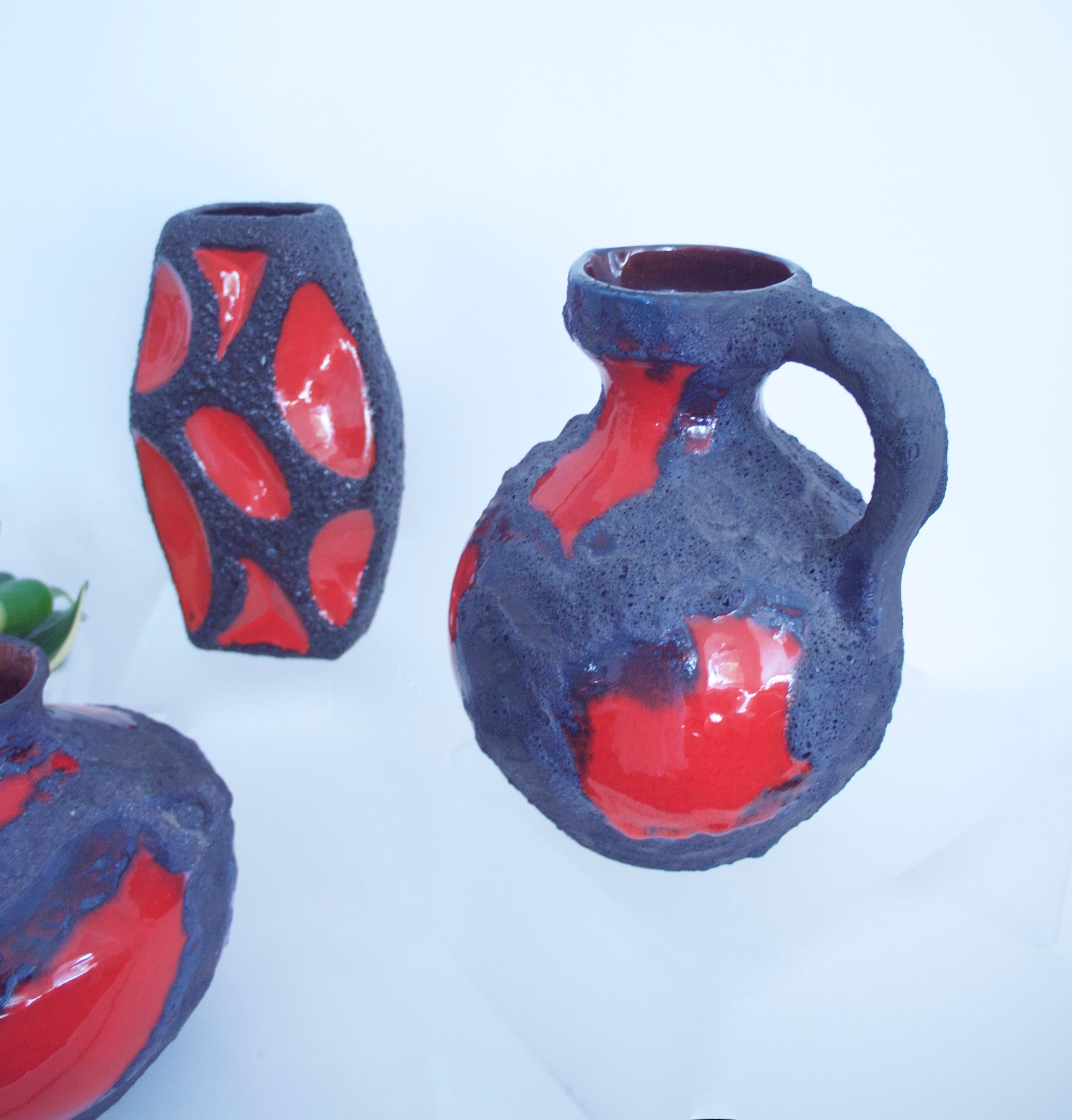 Modernist fat lava Space Age collection consisting of 3 red ceramic vases by Roth/Marei, 1970s.

These two manufacturers are intertwined and some of the work historically considered to be by Roth was made by Marei and simply re-labelled.

Here