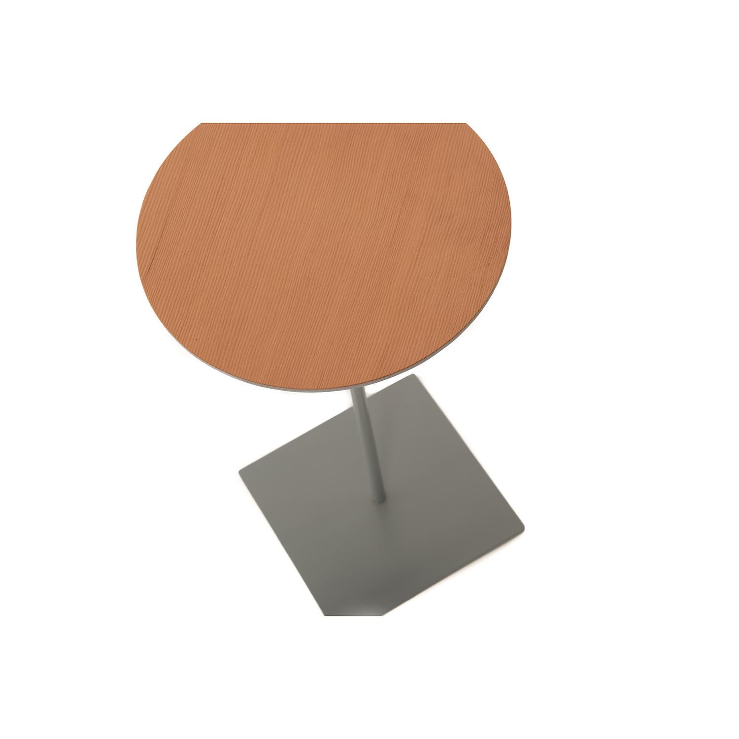 This round top fir table sits upon a slender, gray stem with a square base.