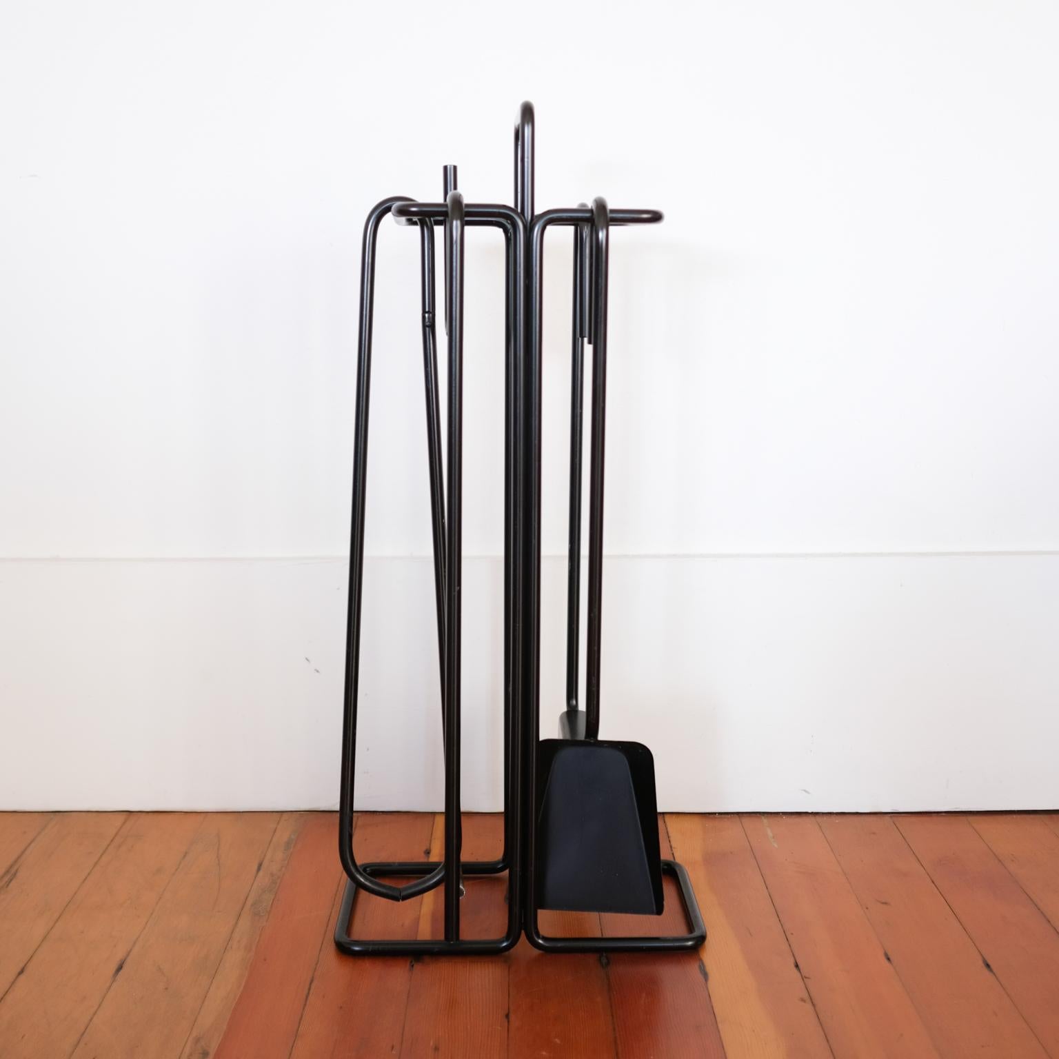 Set of iron fire tools hung on a sculptural iron stand. A striking and functional minimalist design. The set, called Mace-Line, was designed by Ann Maes, an American, and made in the Netherlands. 1970s.