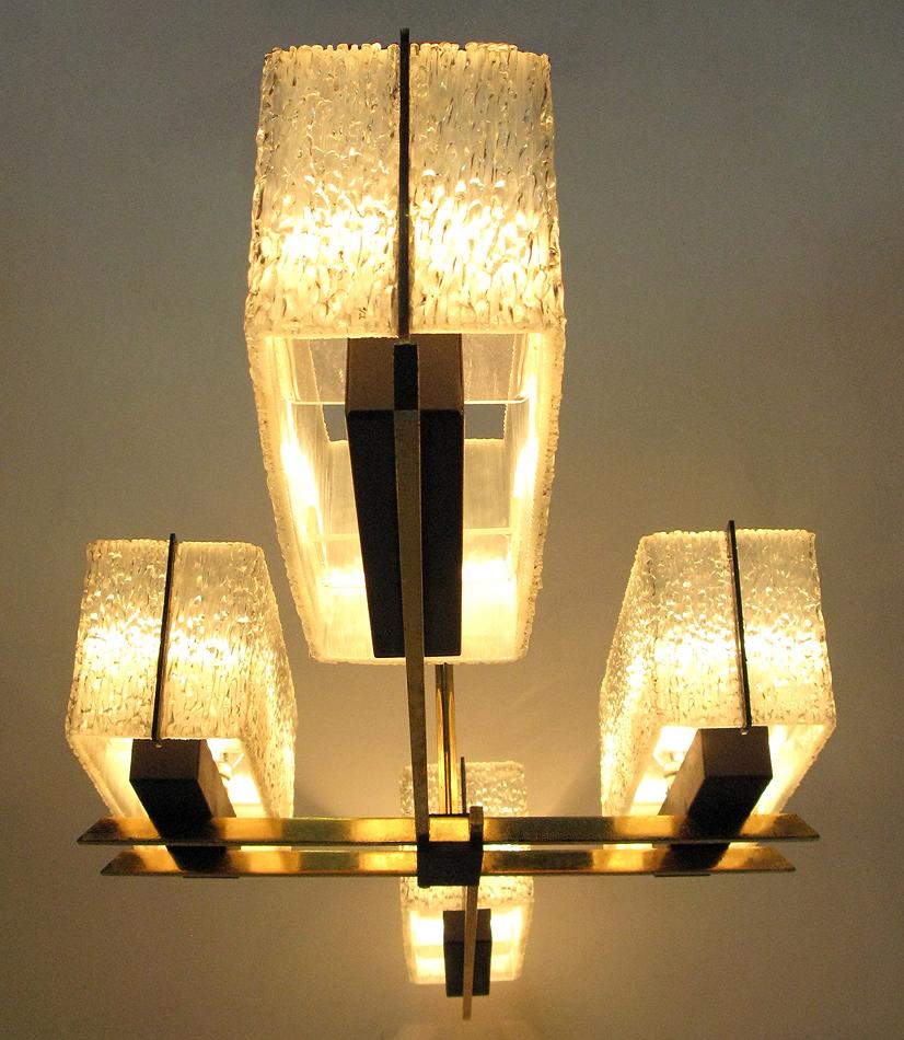 A large, geometric 1960s chandelier by French makers Maison Arlus.

The same chandelier is featured in the Madmen meeting room.

In brass and steel with Lucite and perspex shades, the angular form would perfectly suit a hallway or rectangular