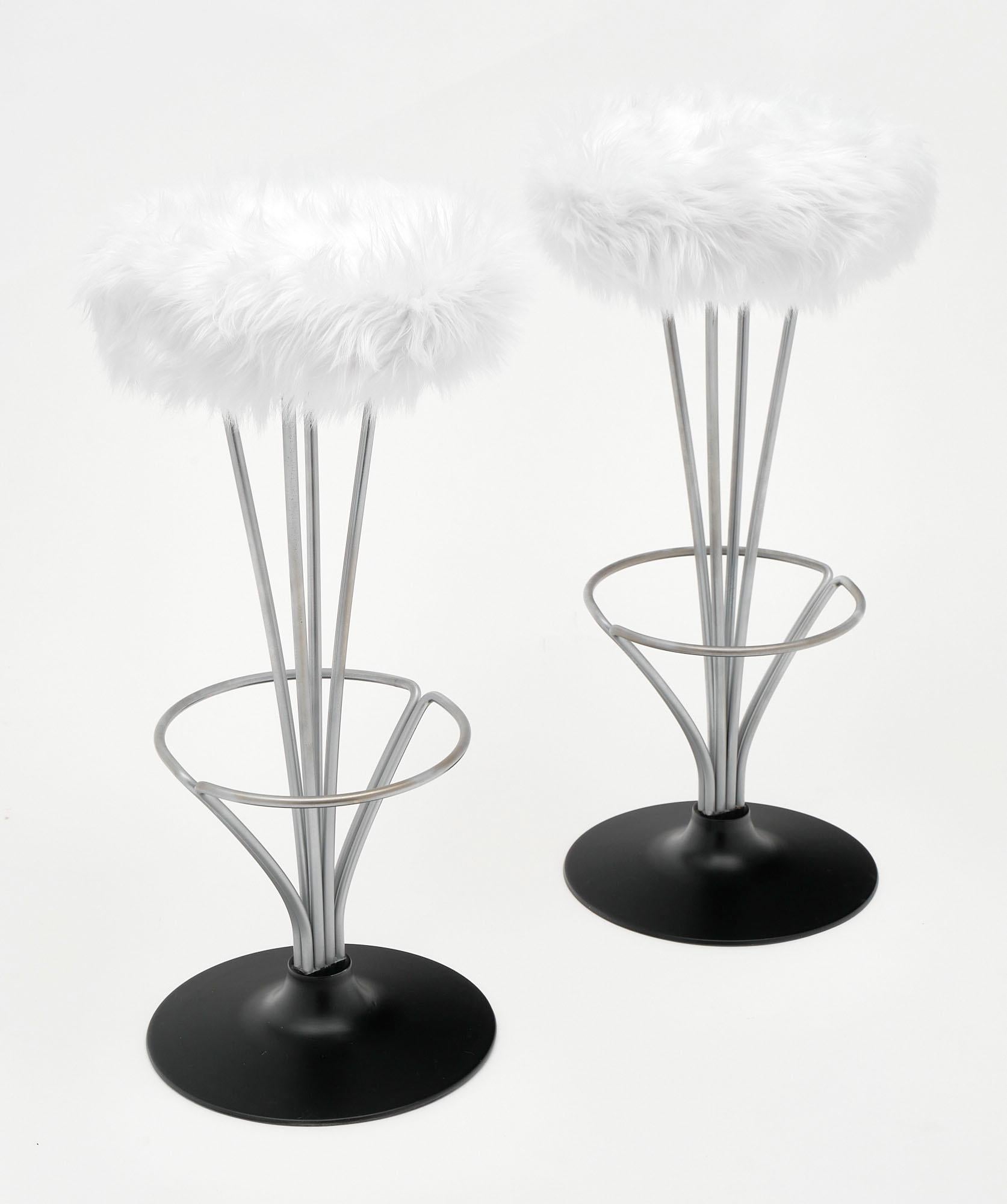 Bar stools from France in the Modernist style. We love the strong construction of the steel bases and black lacquered feet. Each features a foot rest and has been newly reupholstered in a white shag fabric.