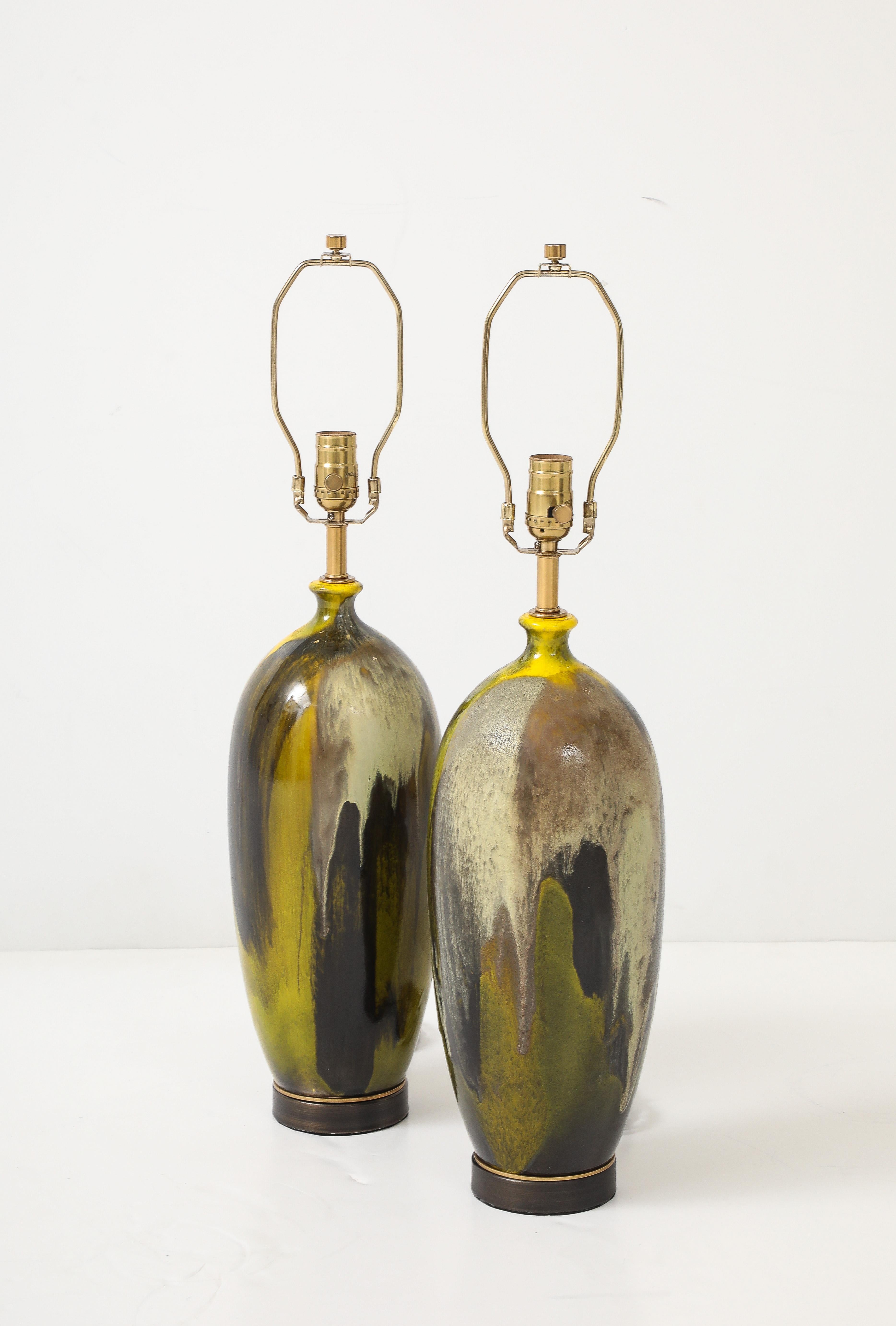 Pair of painterly decorated ceramic lamps featuring moss, dark green, olive hues. Mounted on bronze bases. Rewired by an UL listed electrician for use in the USA.