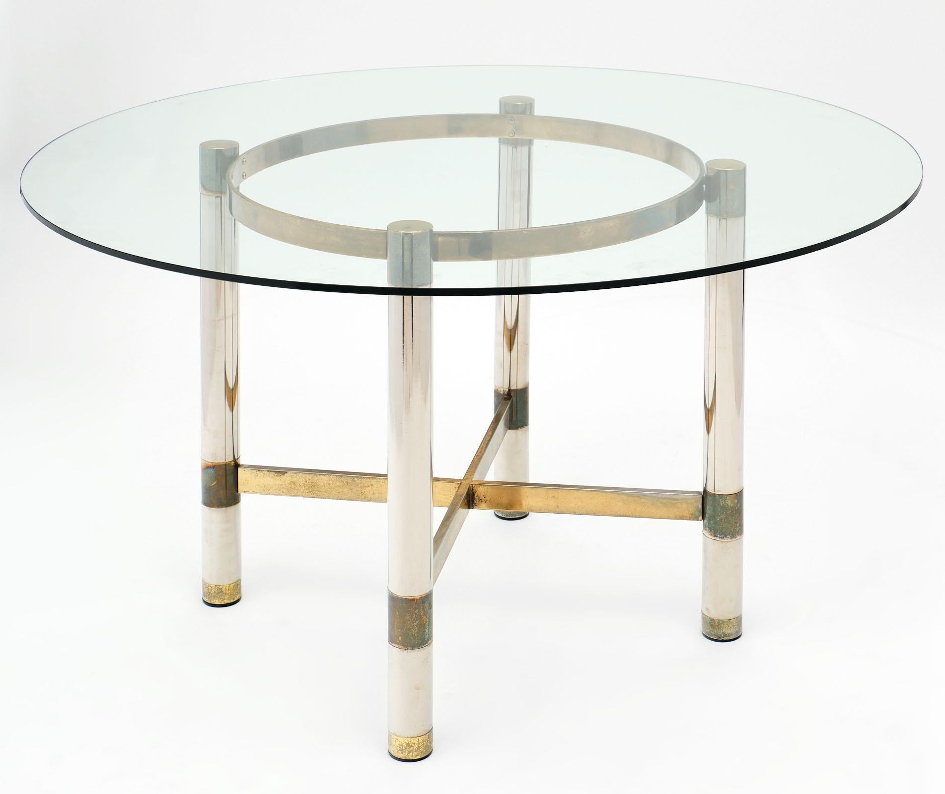 French modernist dining set. The table base is made of brass and chrome with a circular glass top. The chairs are upholstered with the original vinyl and feature Lucite on the backs of the chairs. We love the eye-catching details of this set. The