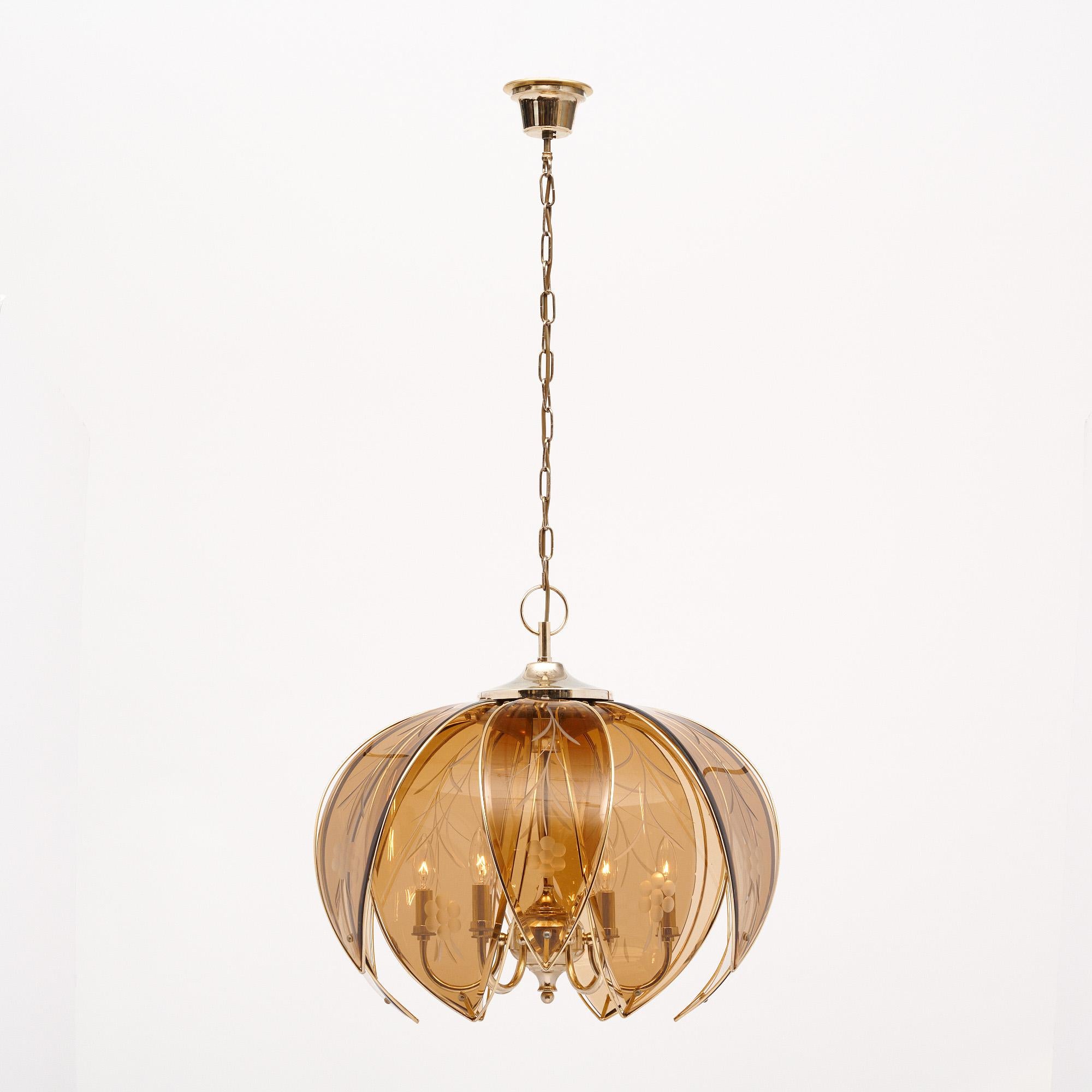 Lampadario del periodo modernista in Francia. Questo pezzo è realizzato con petali stratificati di vetro ambrato fumé cesellato e rifinito con ottone. Ogni petalo presenta un motivo floreale inciso sul vetro. Ci sono sei bracci di ottone all'interno